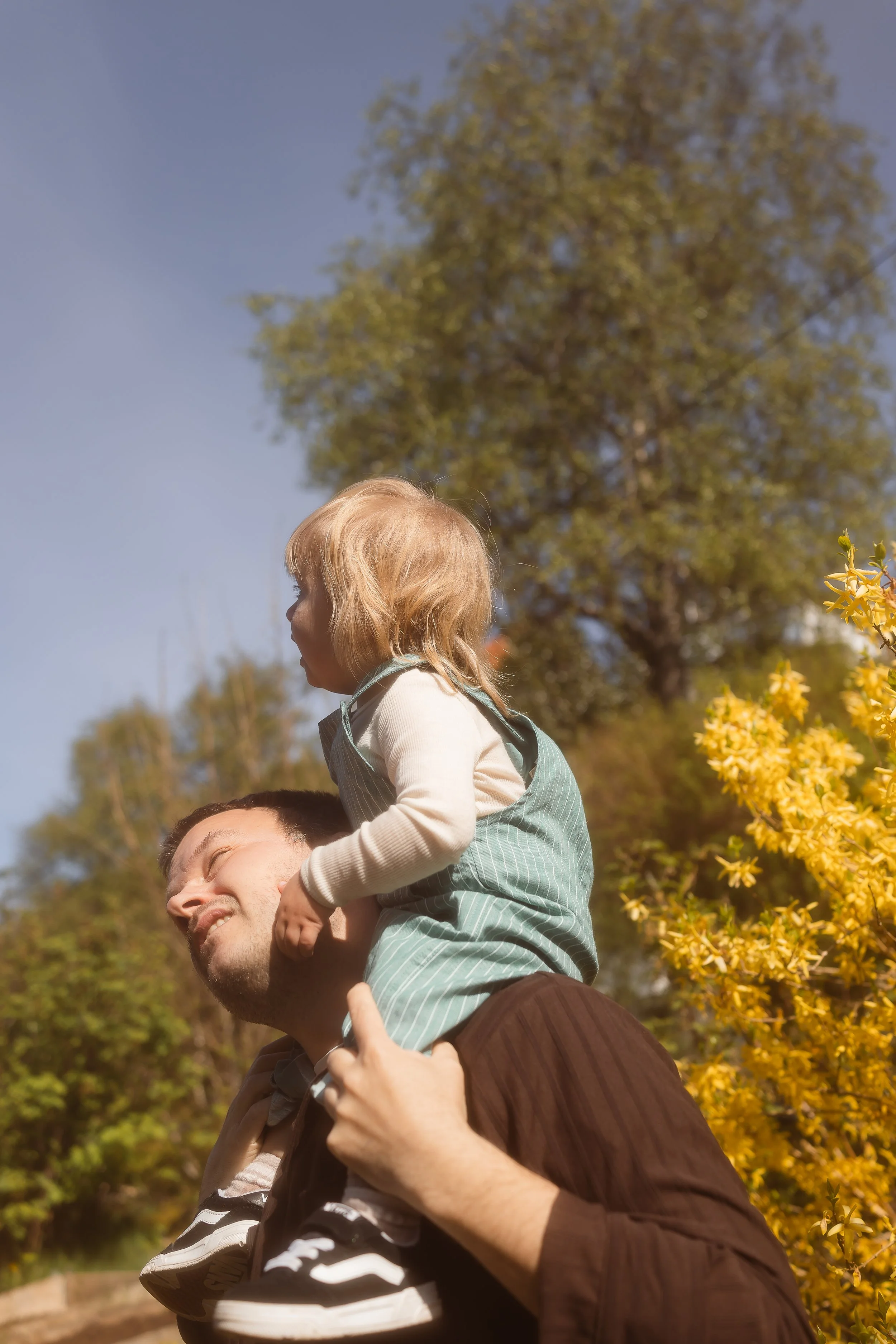 sønn som sitter på skuldra til pappaen 