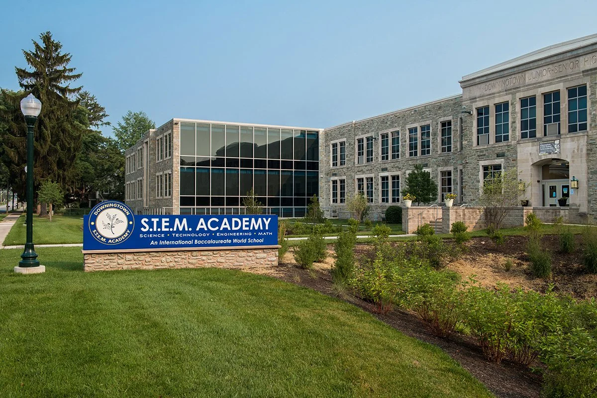 Exterior of Downingtown S.T.E.M. Academy building with a sign and landscaped grounds.