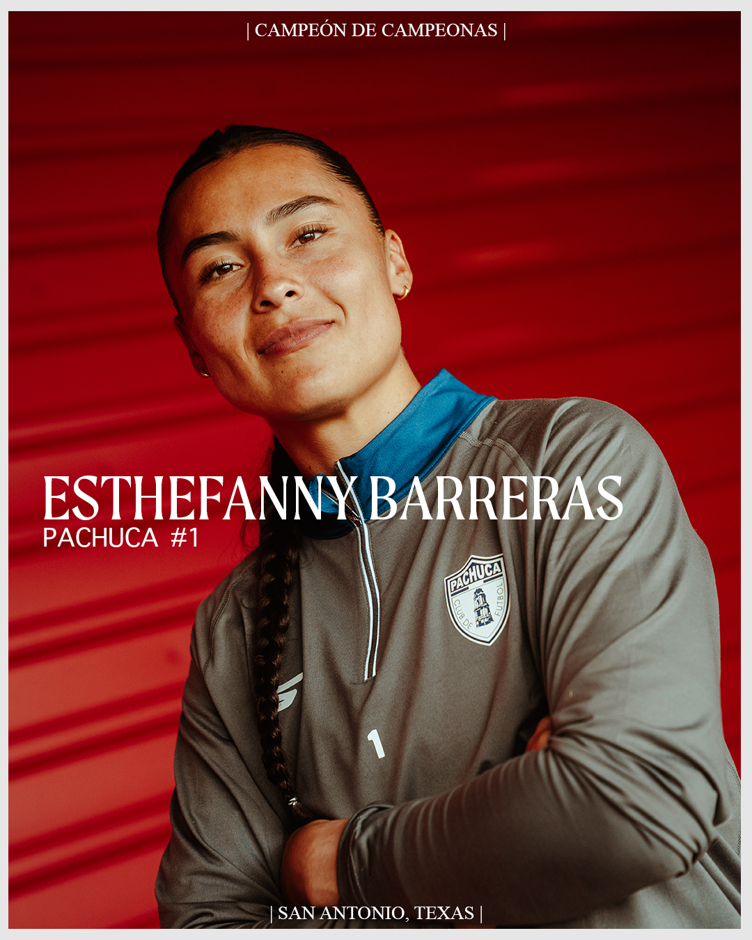 Portrait of Esthefanny Barreras, a female athlete, wearing a Pachuca soccer team jacket, with braided hair, against a red background, smiling confidently.