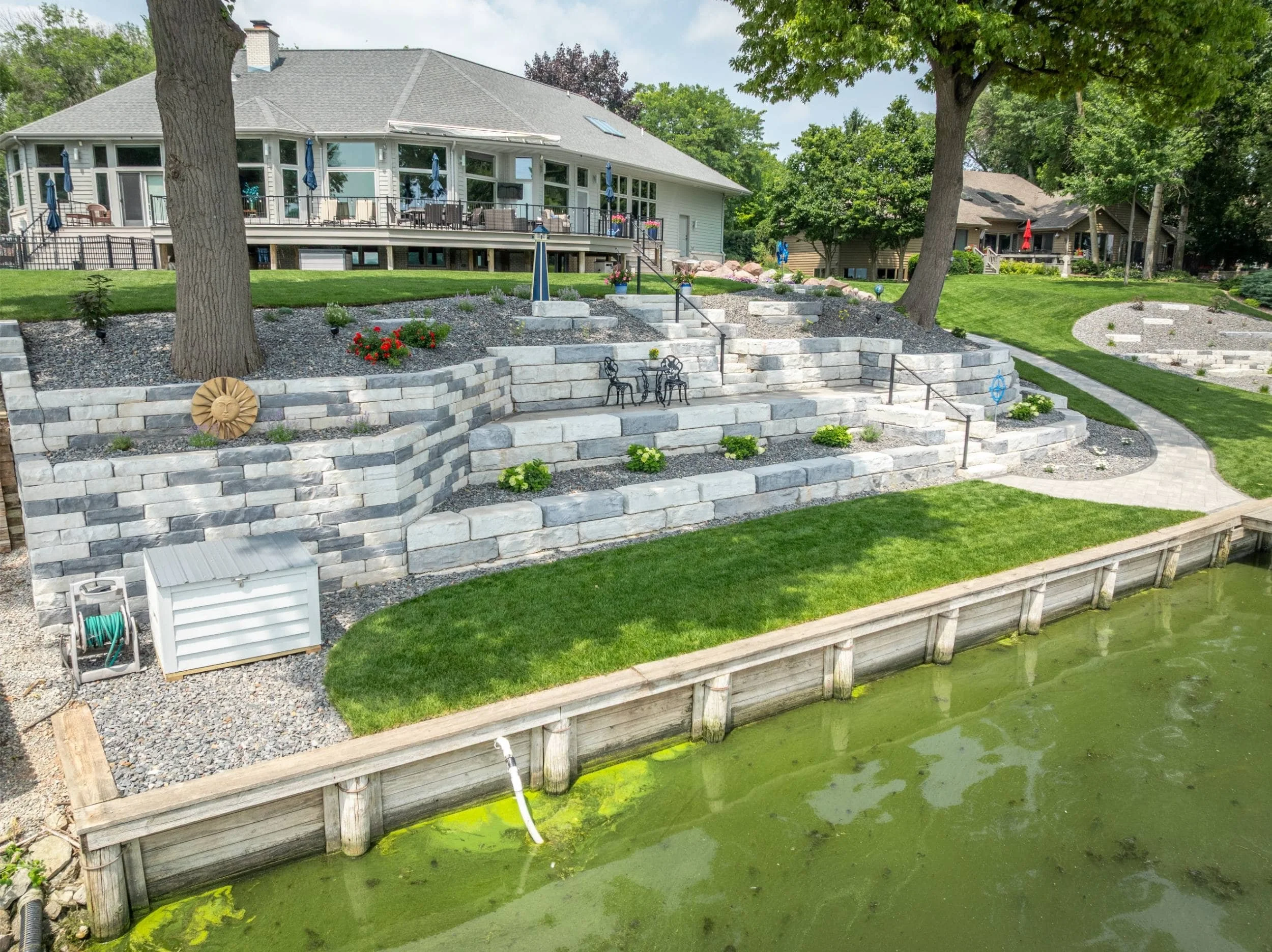 A custom landscape featuring a pergola and mature trees in Fox Valley, WI