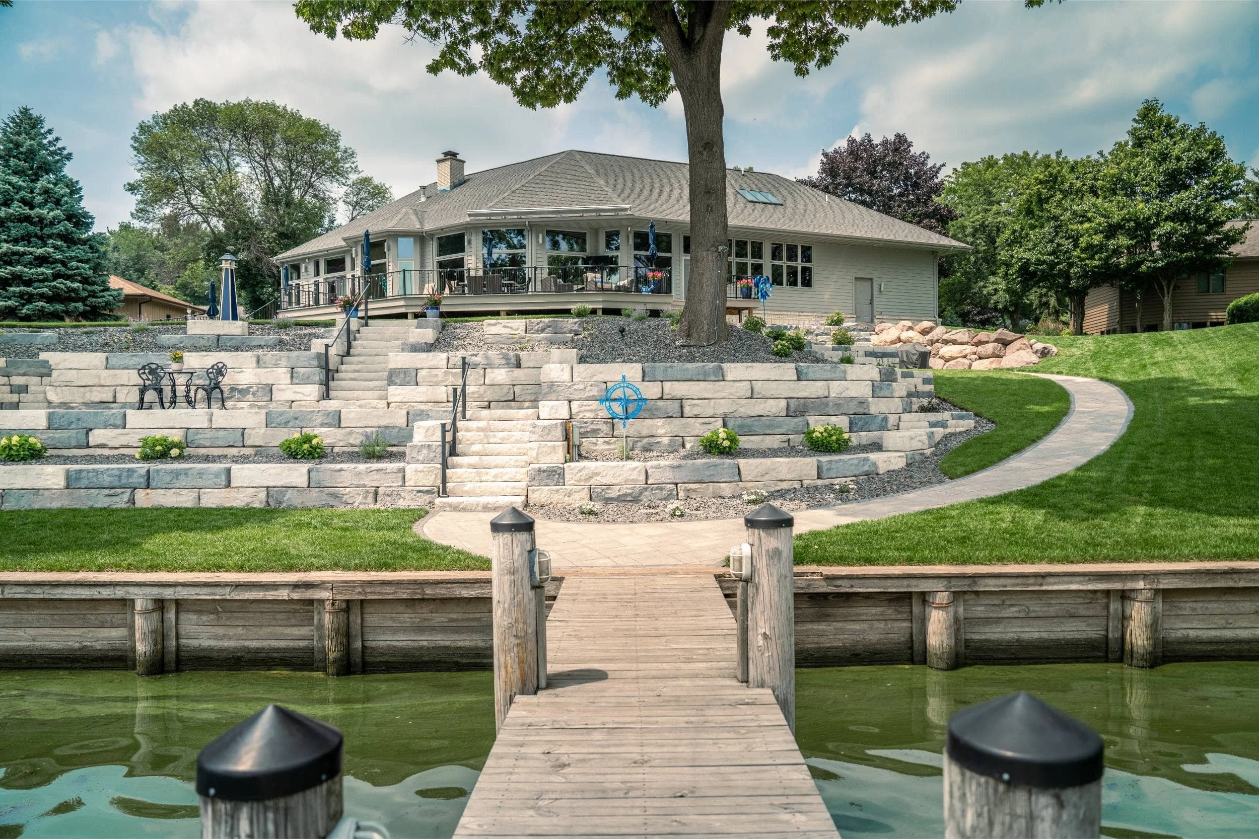 A waterside retreat featuring a pergola and soft landscape lighting in De Pere, WI