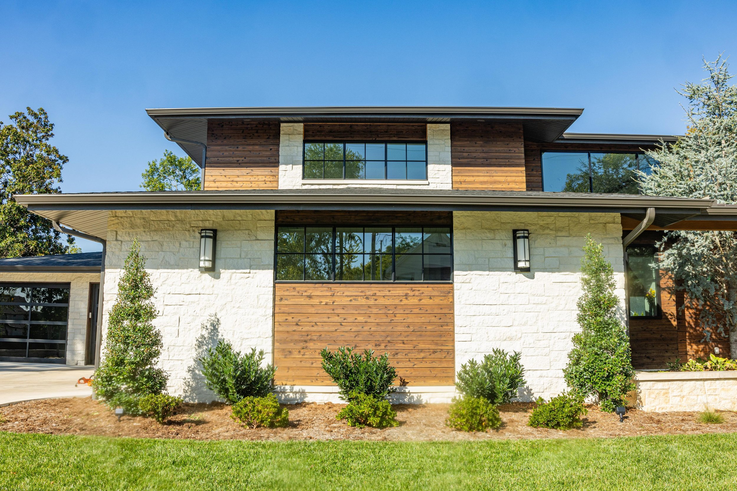 Front entrance with green plants surrounded by healthy mulching