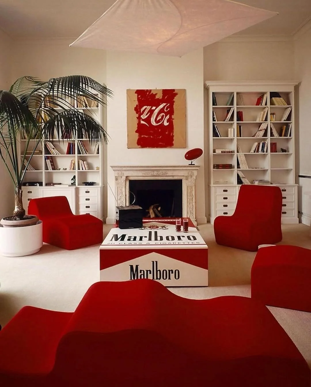 Rome, 1983. 
Architects Patrizio Paris and Patricia Pietrogrand crafted a space that feels more pop manifesto than living room. 

Marlboro table, Coca-Cola canvas, and those deep red curves, pure theatre. Shot by the legendary Carla De Benedetti.

#S