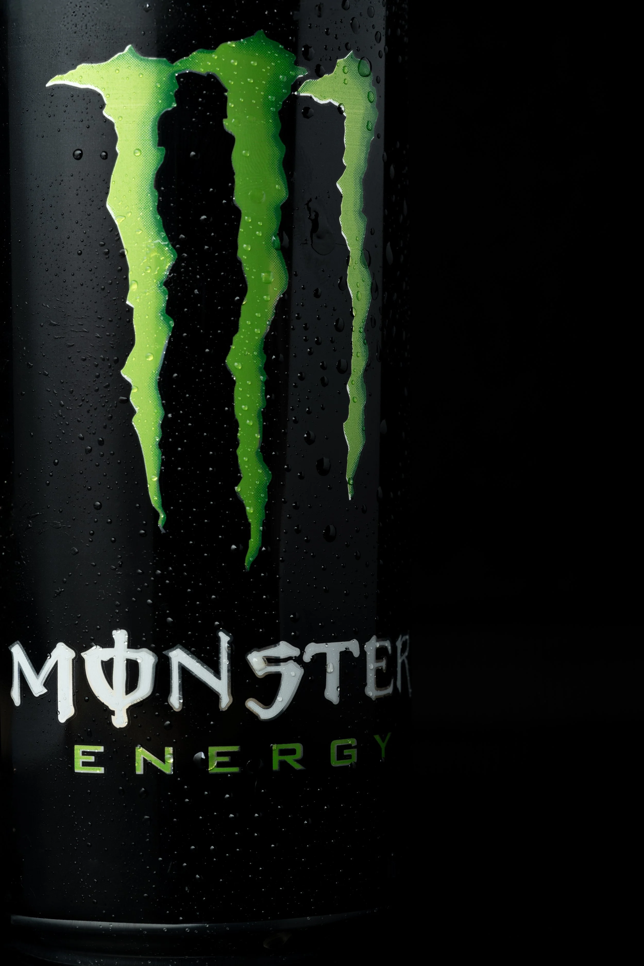 Close-up of a can of Monster Energy drink with water droplets on the surface.