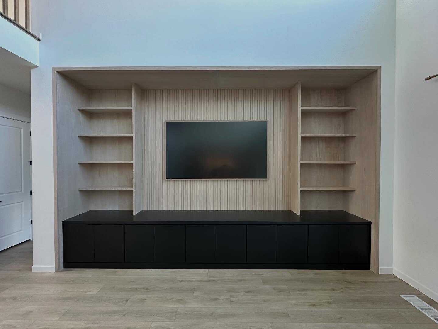 👀Check this one out!!👀
The combination of white oak and black are always a crowd pleaser! This 100% custom built showcase of a built in, is absolutely gorgeous! With custom built black cabinetry and white oak shelving,  finished with a stunning sla