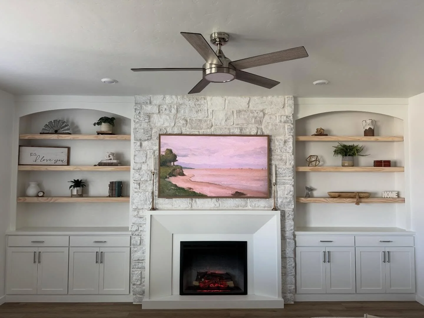 This living space received the ultimate upgrade! Beginning with a blank slate and ending with a gorgeous 100% custom built floor to ceiling stoned fireplace, stunning mantle, arched bookcases, natural wood shelves and shaker cabinets! This space prov