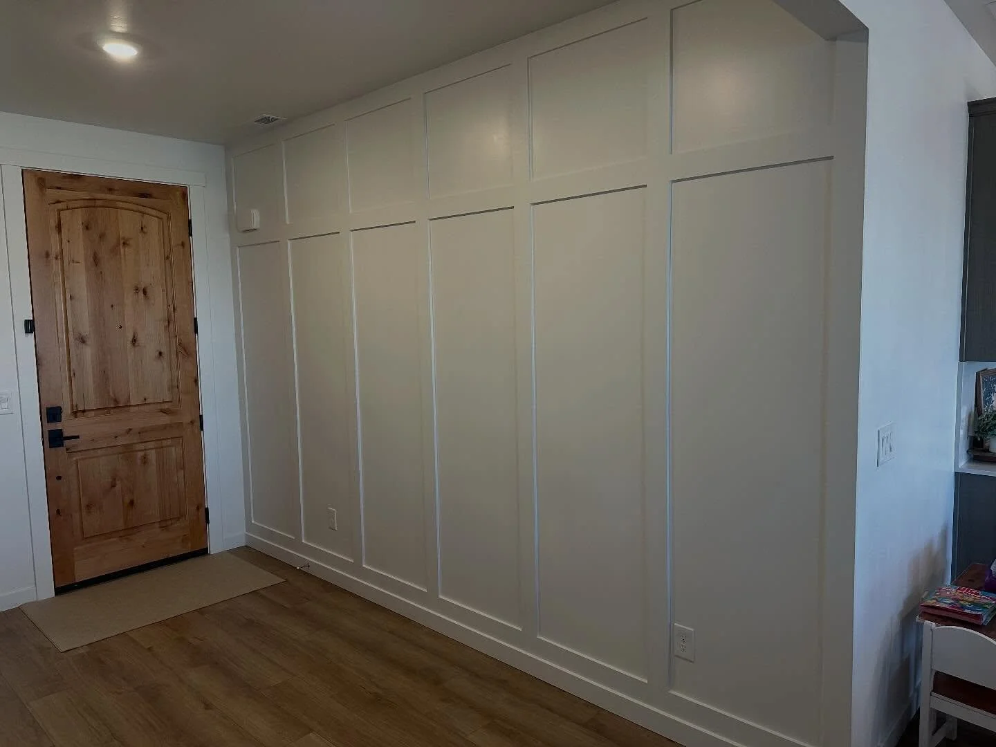 Board + Batten adds such a clean and timeless design to any space! This entry way looks absolutely stunning after the addition of a clean and crisp craftsman style board + batten. Showing off the height and creating a perfectly cozy entrance into the
