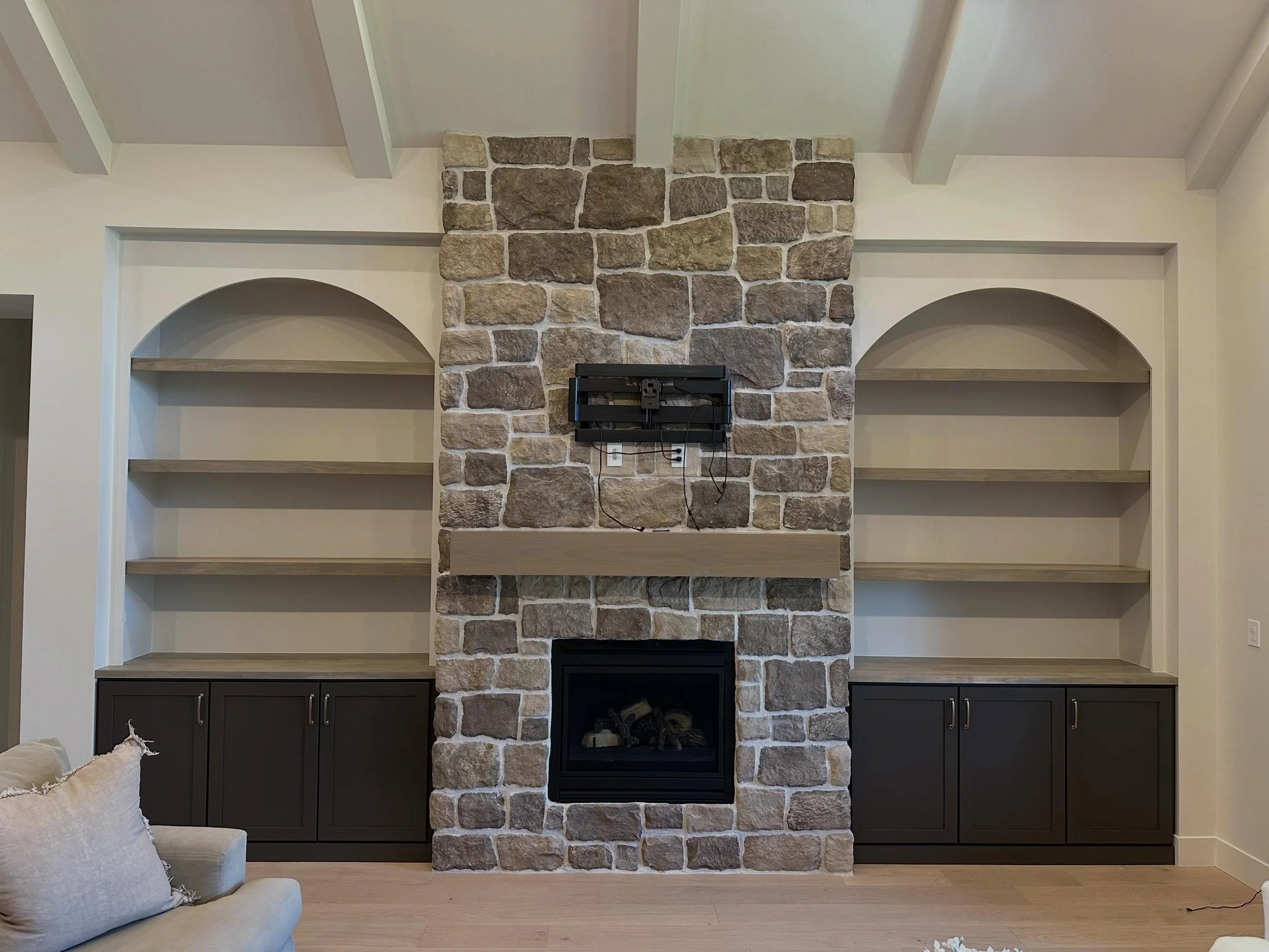 100% custom and 100% gorgeous!! 
This beautiful home received the perfect addition to finish off their fireplace! Custom built shaker style cabinets; finished in a stunning color. Paired with breathtaking arched bookshelves that coordinate beautifull