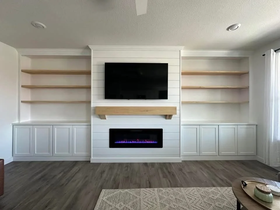 Custom shiplap fireplace wall with white built-in cabinets, floating wood shelves, and a modern electric fireplace in a Caldwell, Idaho home.
