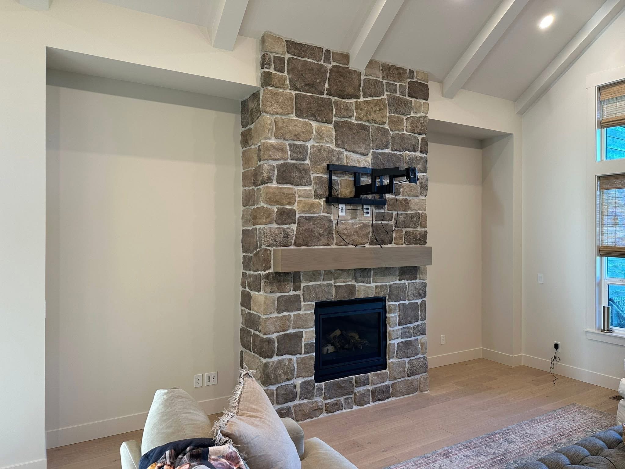 Before view of a stone fireplace before adding custom built-in cabinetry and arched shelving in Kuna, Idaho.