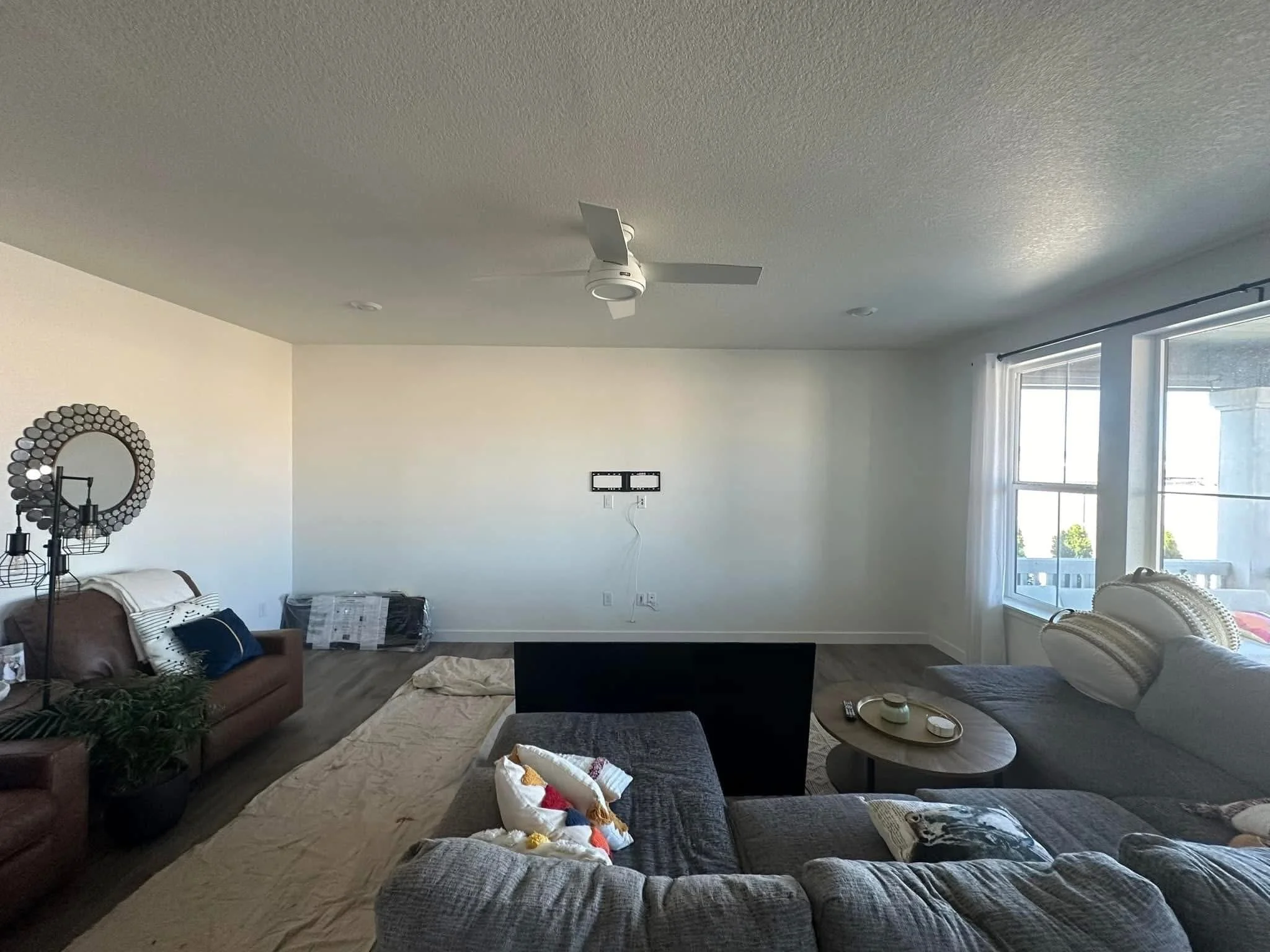 Before photo of a blank living room wall before installation of a custom entertainment center and fireplace feature wall in Caldwell, Idaho.