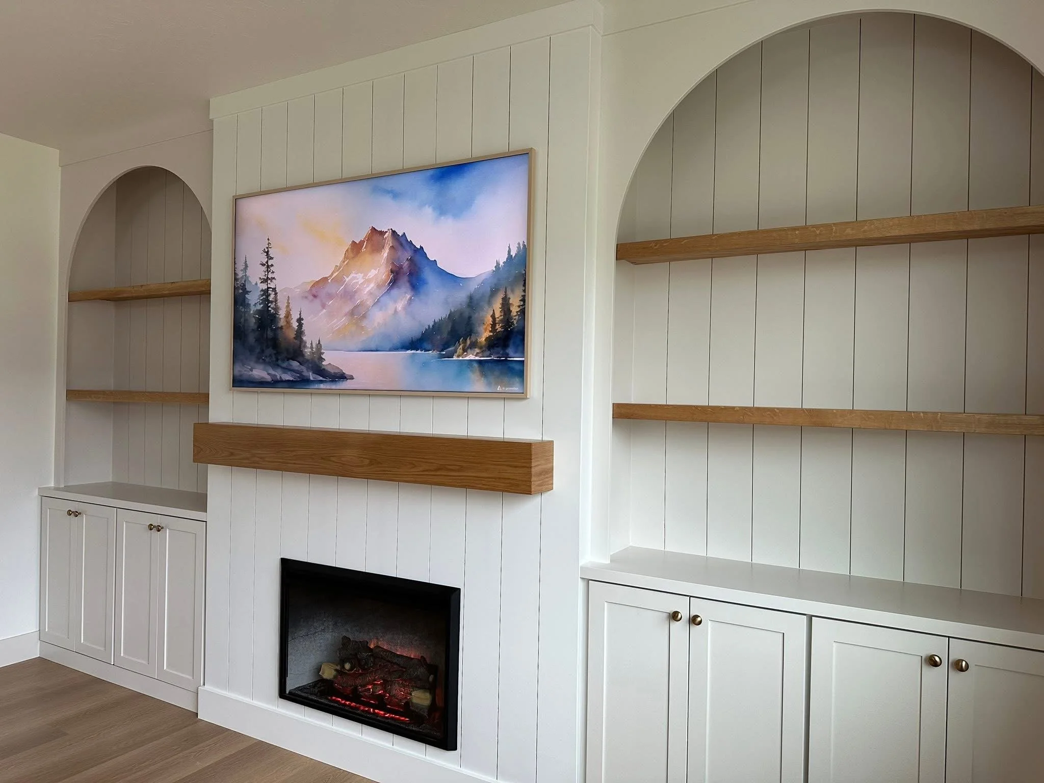 Modern built-in cabinets with arched shelving, vertical shiplap, and a custom fireplace surround in Meridian, Idaho.