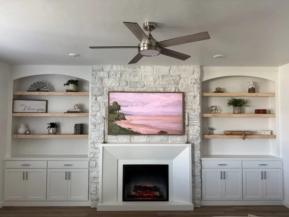 Before and after of a custom stone fireplace with arched built-in shelving, floating wood shelves, and lower cabinets in Caldwell, Idaho.