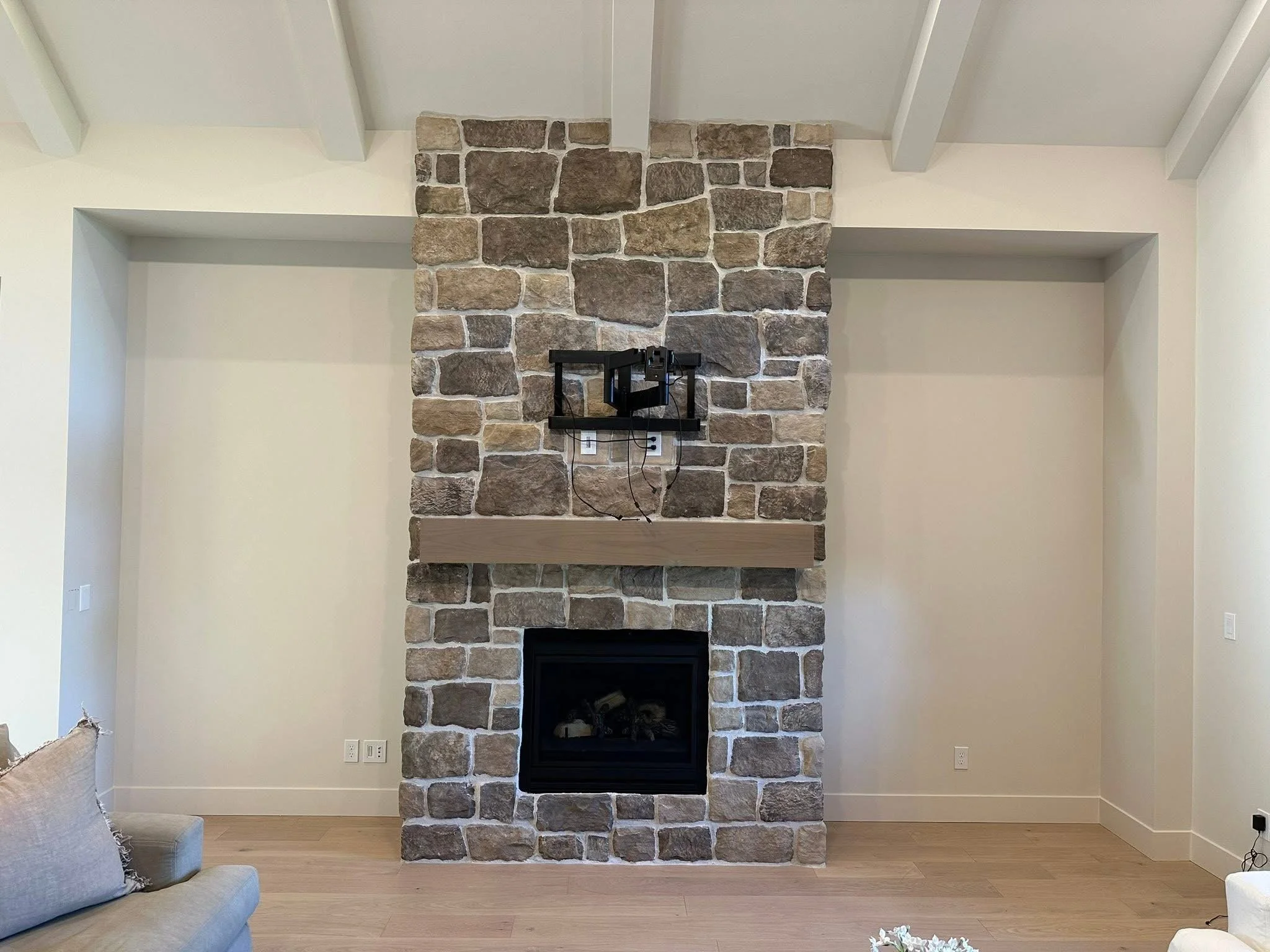 Before photo of a stone fireplace wall prior to installing custom arched built-in cabinets and shelving in Kuna, Idaho.