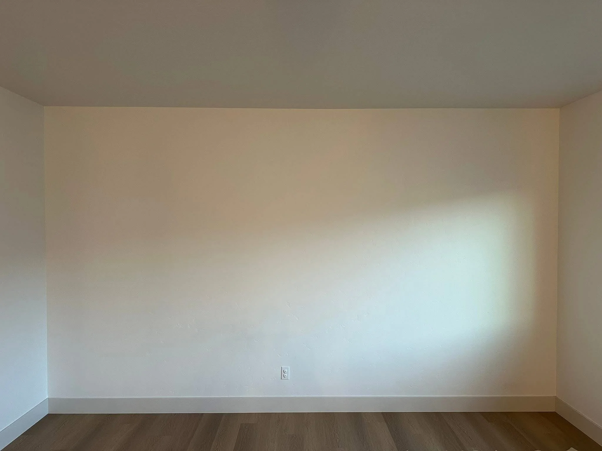 Before photo of a blank living room wall before installation of custom arched built-ins and a fireplace feature wall in Meridian, Idaho.