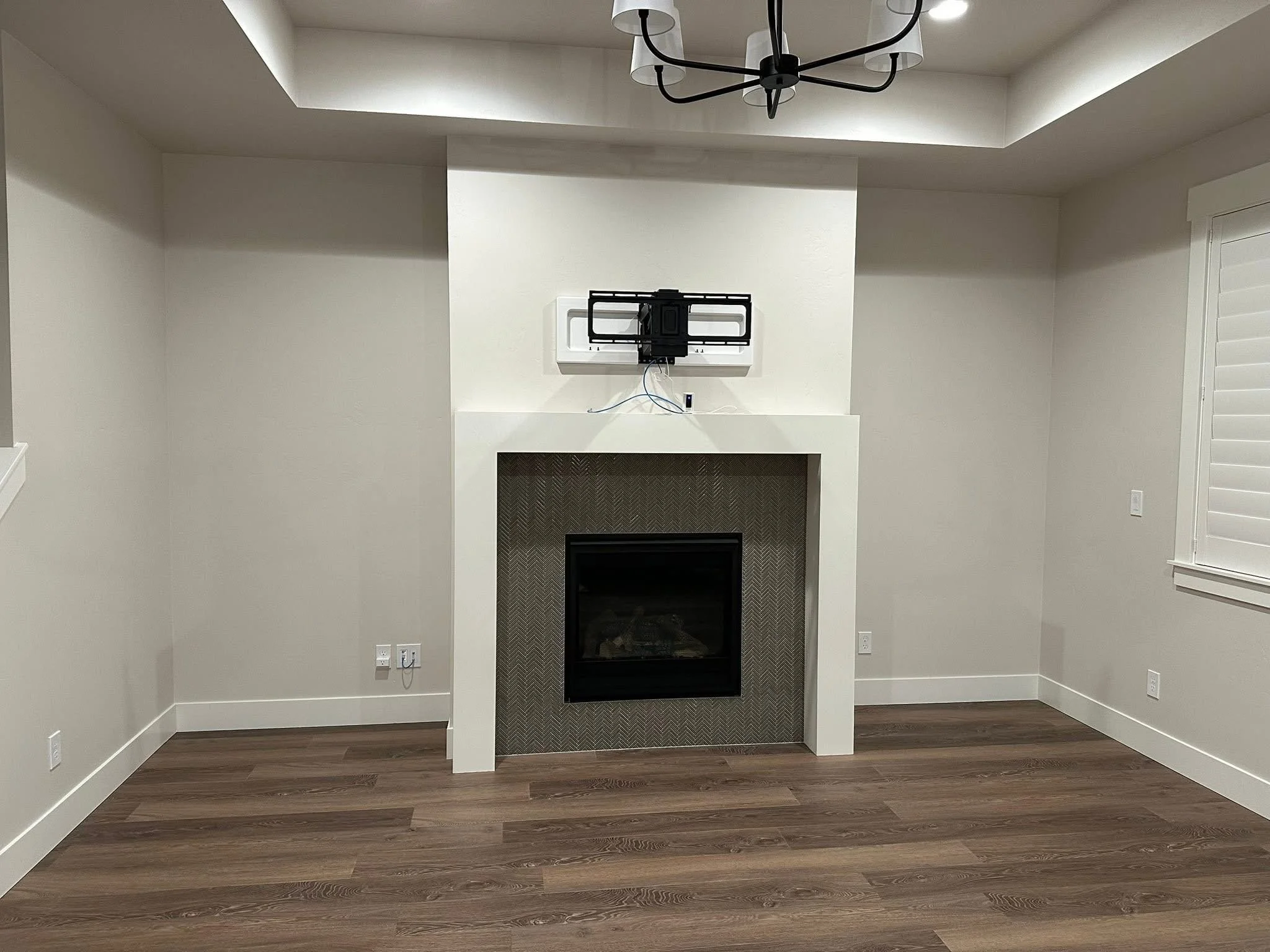 Fireplace feature wall before installation of custom built-in cabinets and floating shelves in a Nampa, Idaho home.
