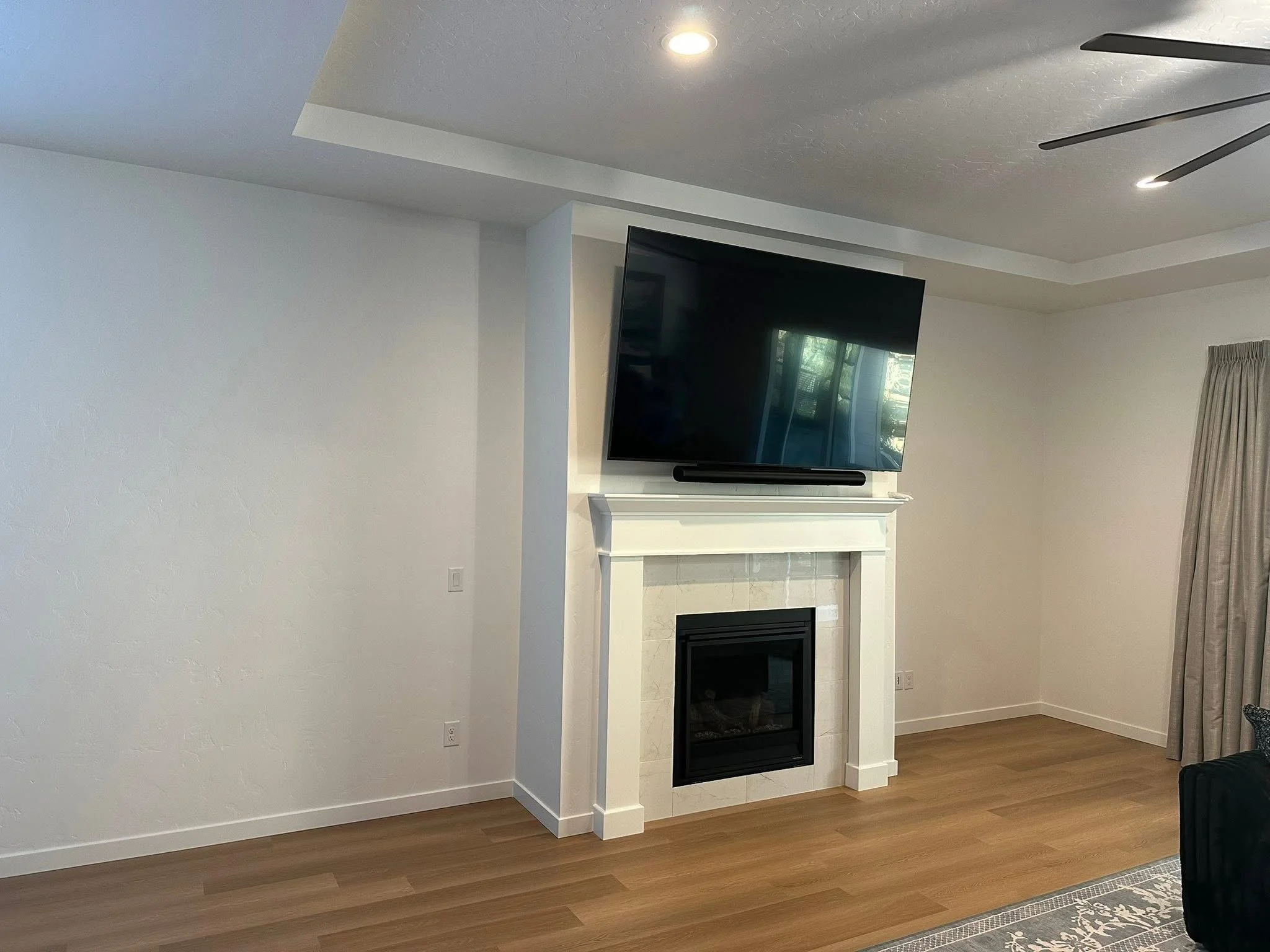 Before view of a blank fireplace wall before adding custom floating shelves and built-in cabinetry in Star, Idaho.