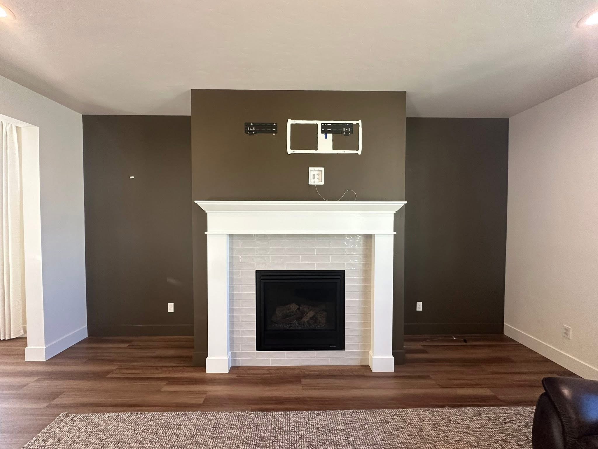Before photo of a fireplace wall before installing custom built-in cabinets and arched bookshelves in Star, Idaho.