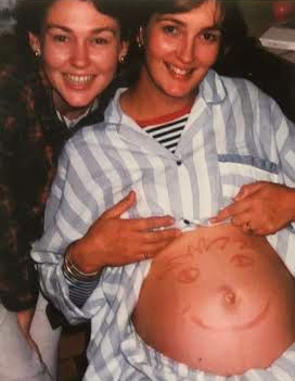 Roz holding her belly that has a face drawn on it with lipstick. 1994 with her friend Kerry.