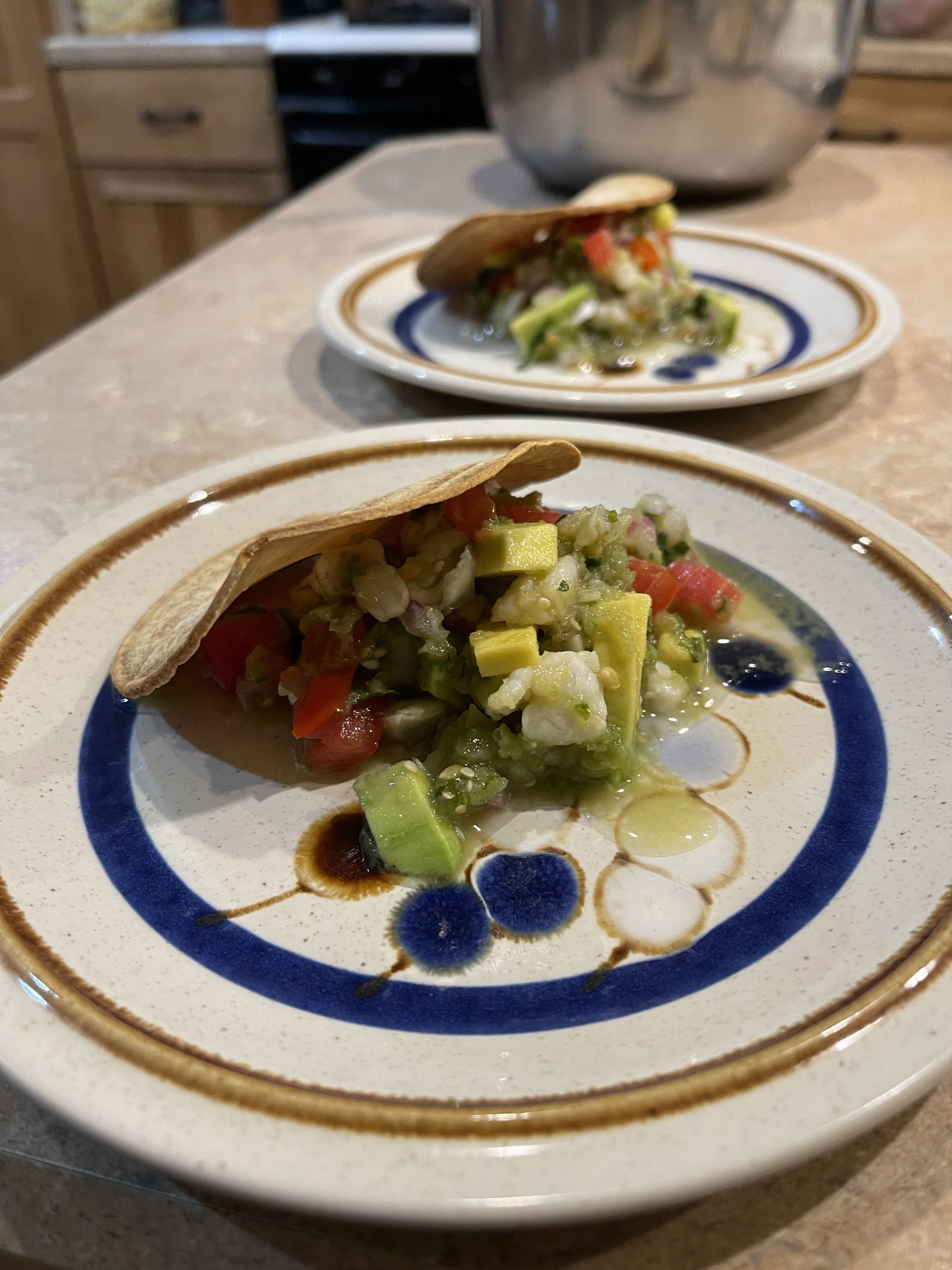 A taco with chopped vegetables on a decorative plate.