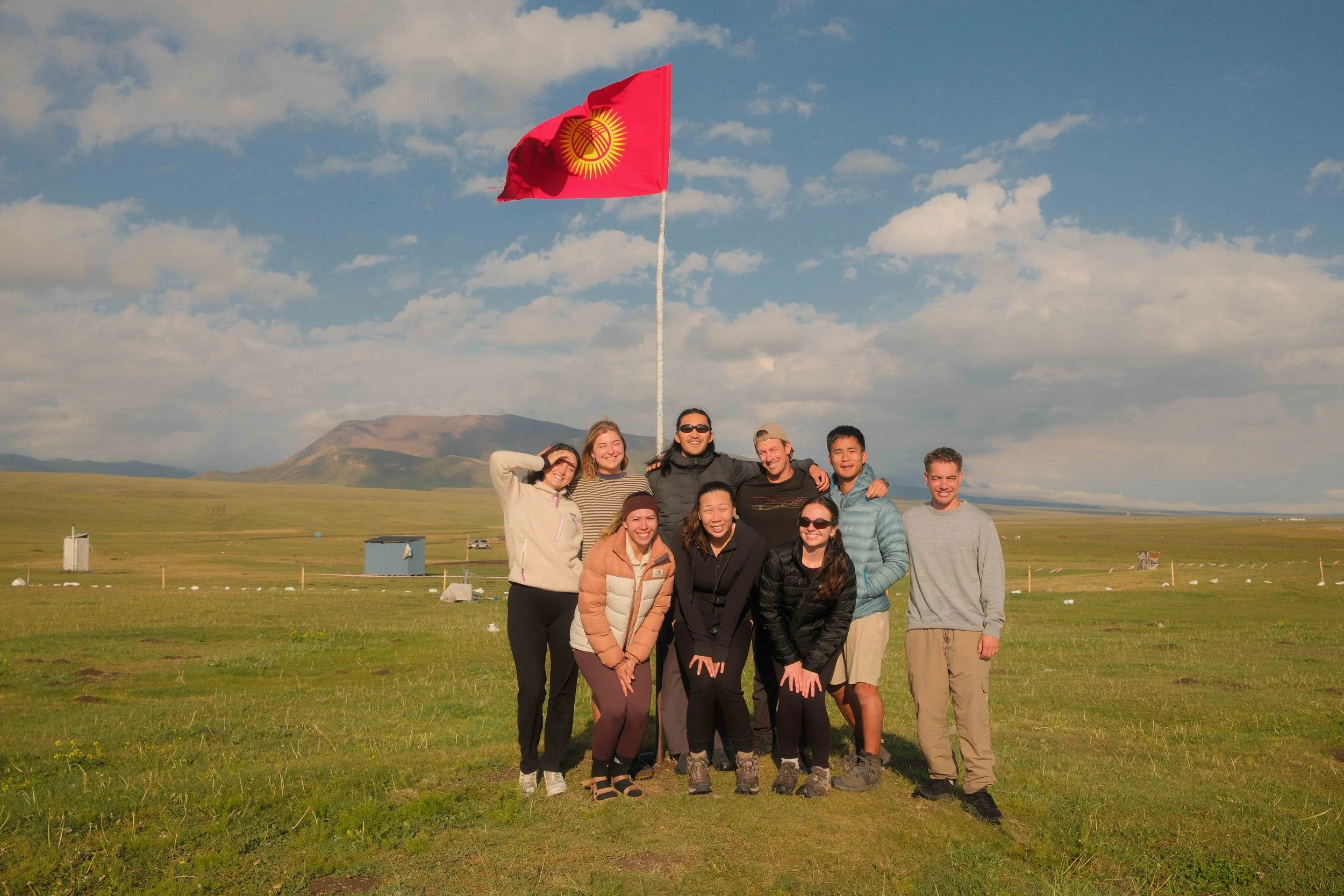 Kyrgyzstan travel group beneath the Kyrgyz flag