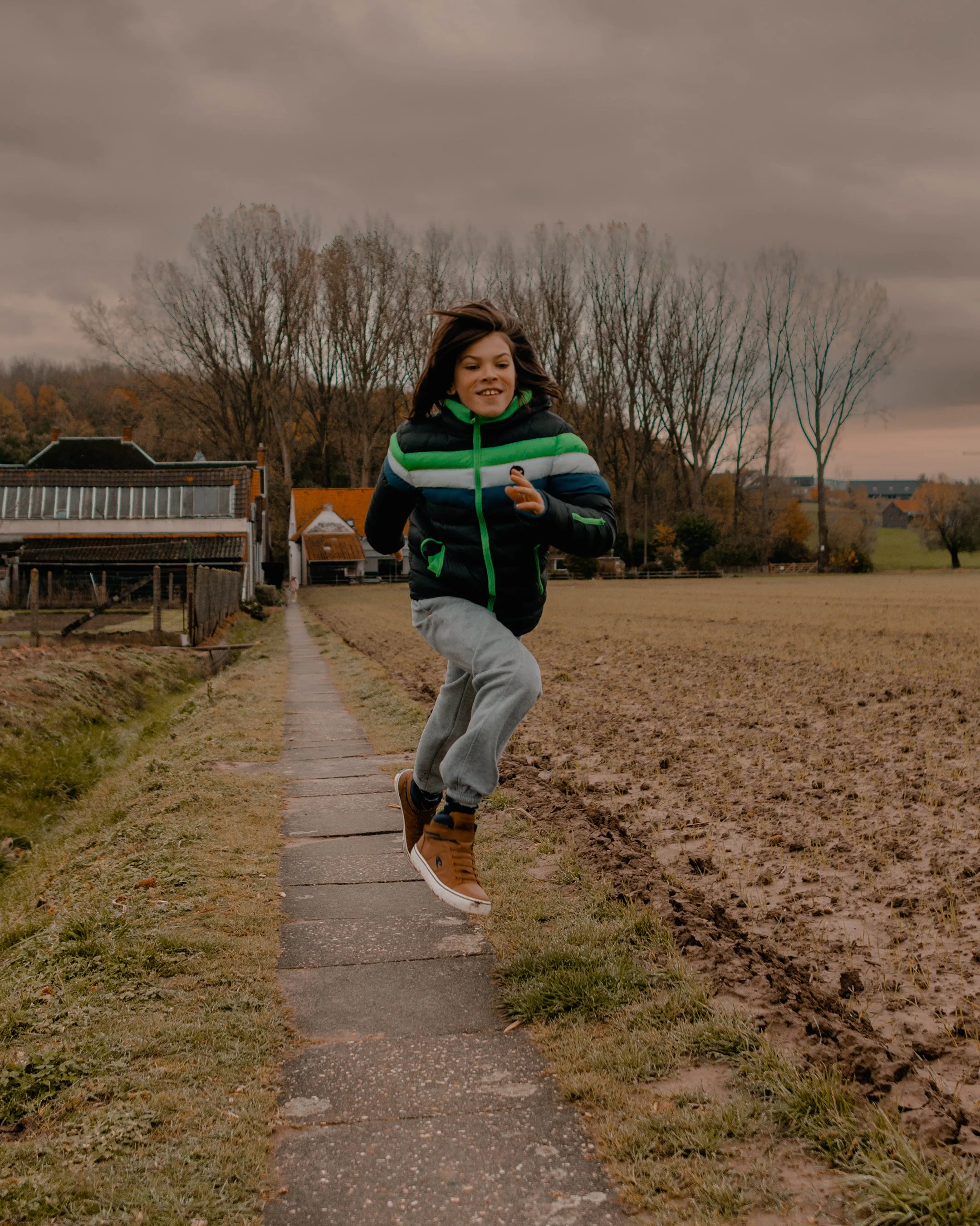Communiefoto kind in bos West-Vlaanderen met natuurlijk licht en zachte tinten byjanox jano 