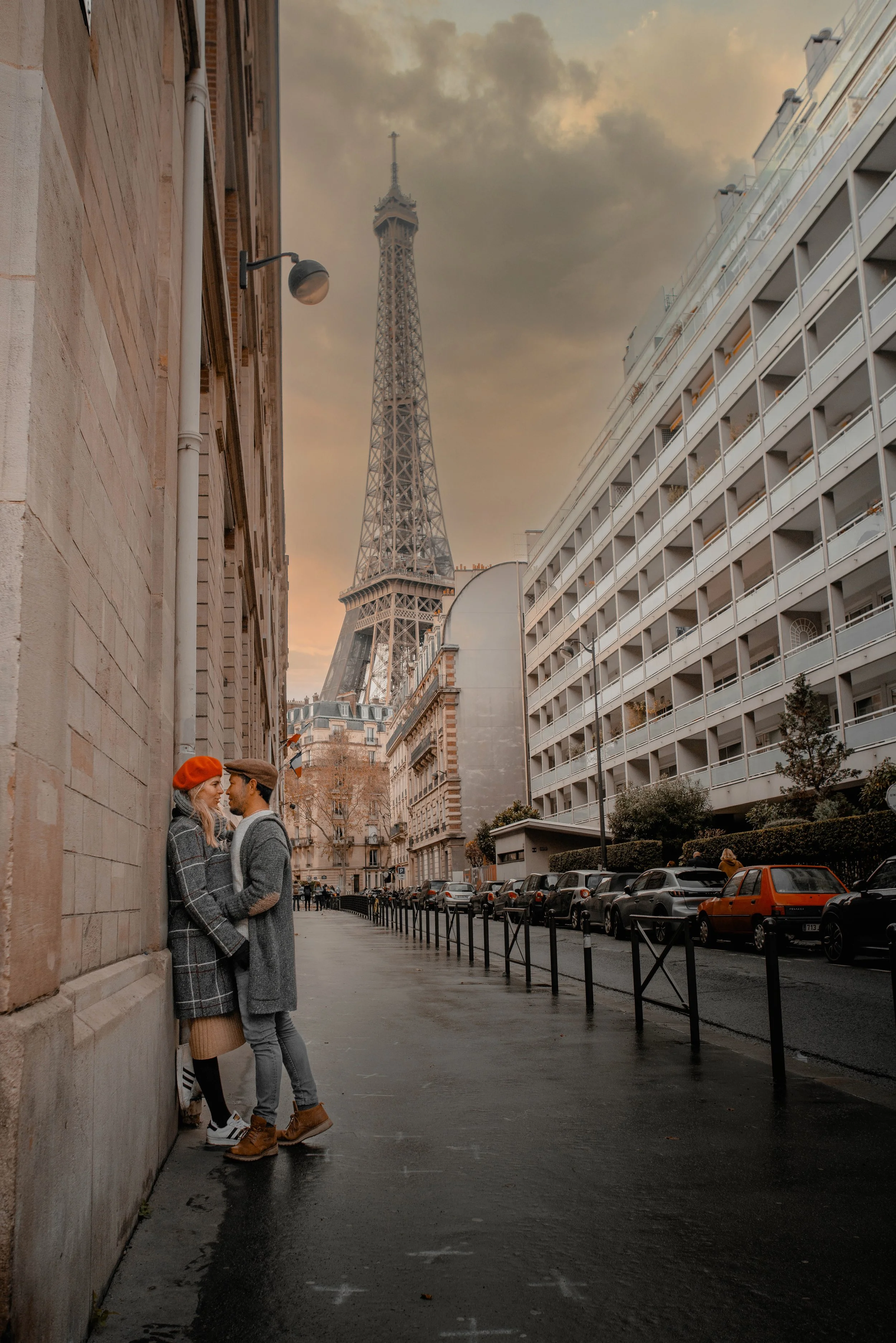 Una pareja de jóvenes en un anuncio romántico en una calle de París con la Torre Eiffel en el fondo.