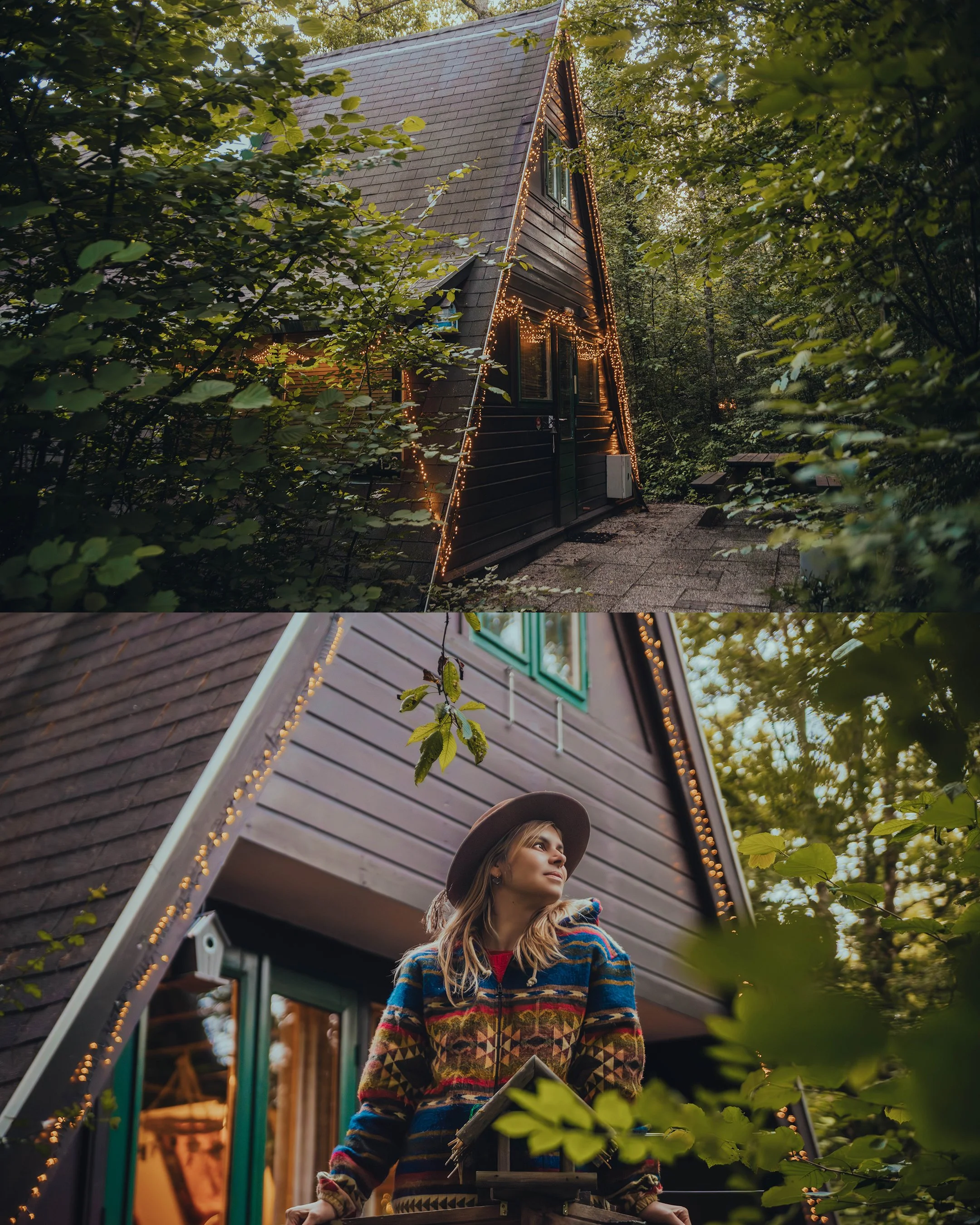 A cozy A-frame cabin decorated with string lights surrounded by lush green trees, with a woman standing outdoors wearing a colorful patterned sweater and a wide-brimmed hat, holding a cookbook and looking thoughtfully into the distance.