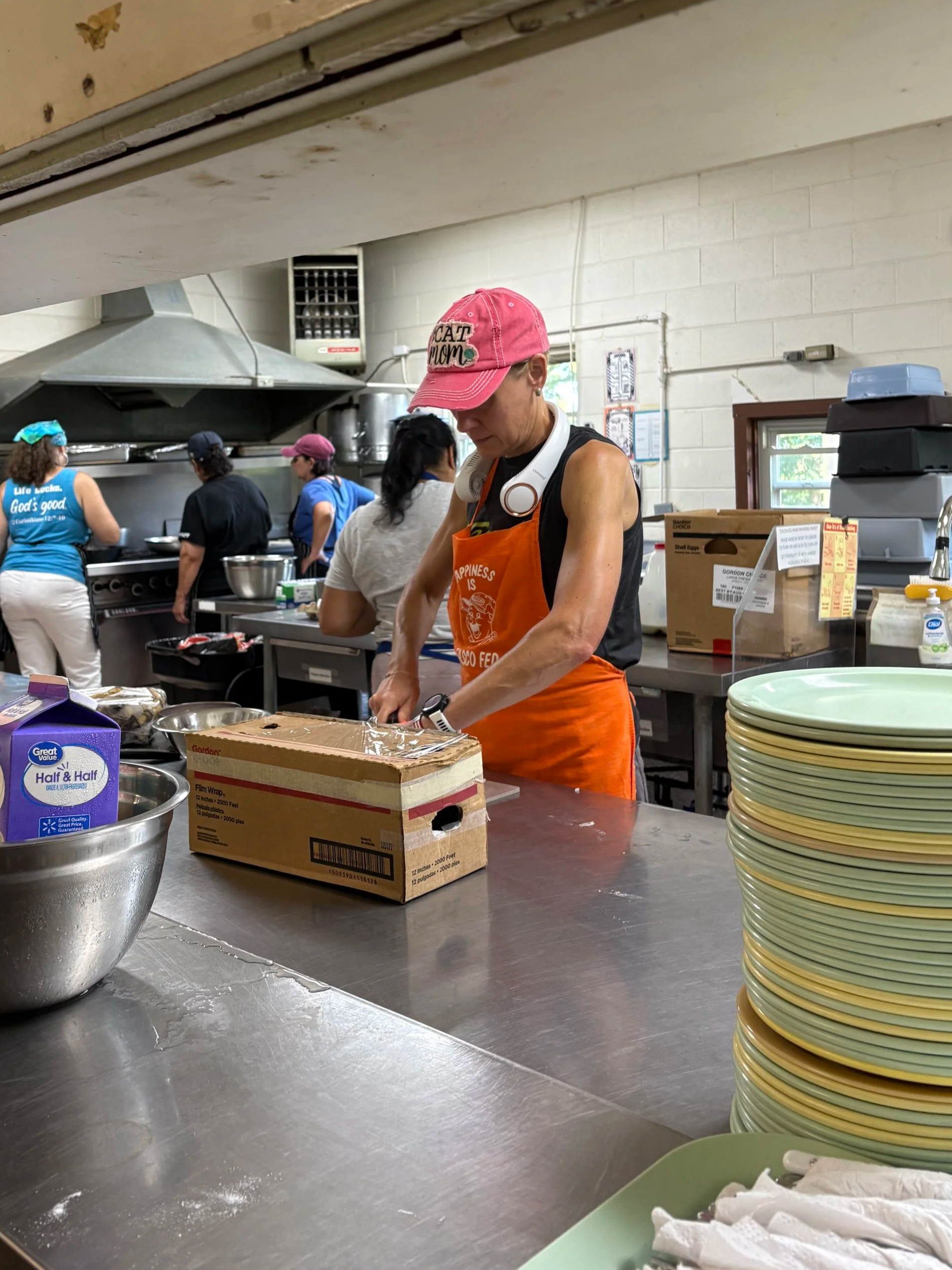 Ashley putting away dishes while volunteering with the kitchen staff.