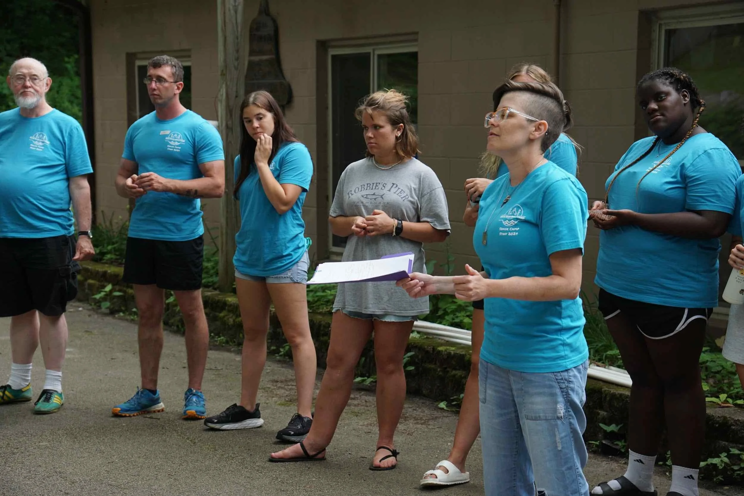 Abby Frye talking to a group of campers by the dining hall.