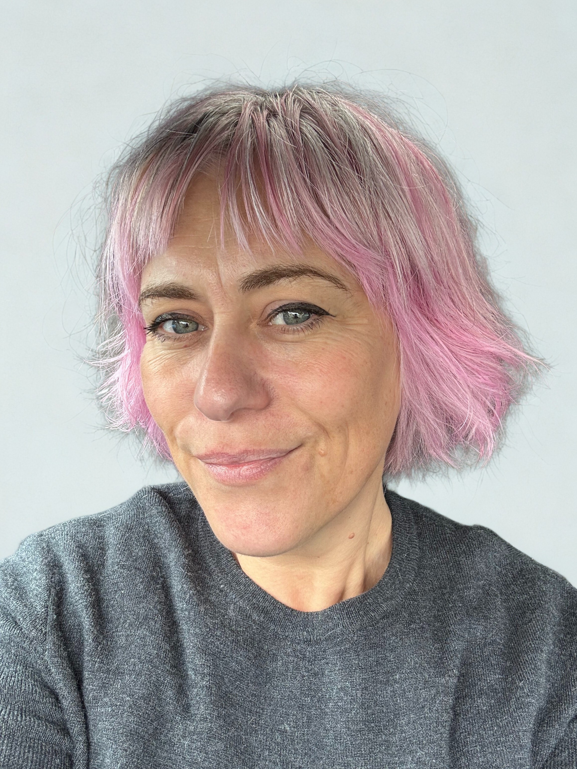 Kim, Founder and Executive Producer of Dash Made Studios, with her signature pink hair in her Bayside creative sanctuary.