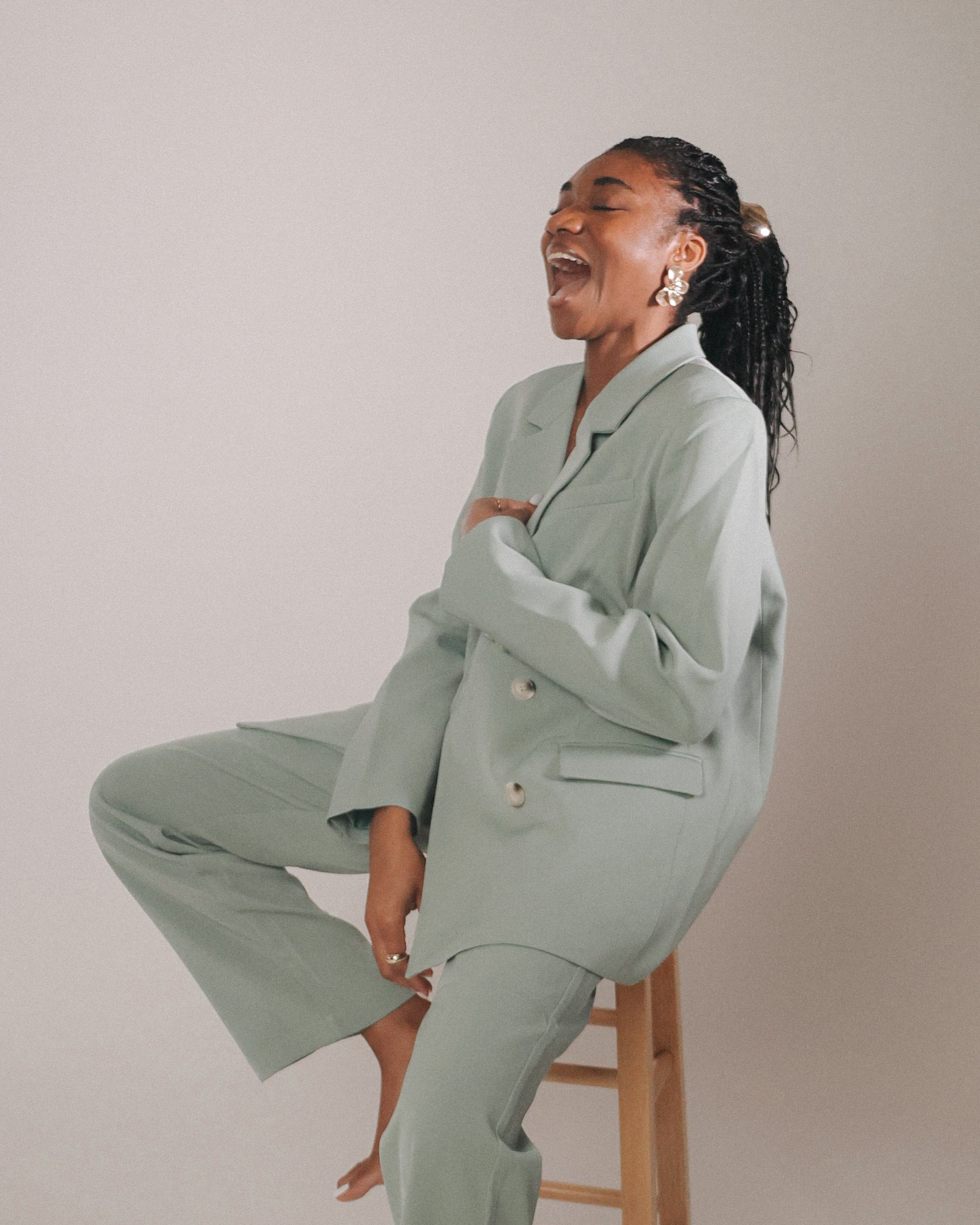 woman sitting on a chair laughing, with a warm smile, Creative Studio Founder in New York, Memkoh