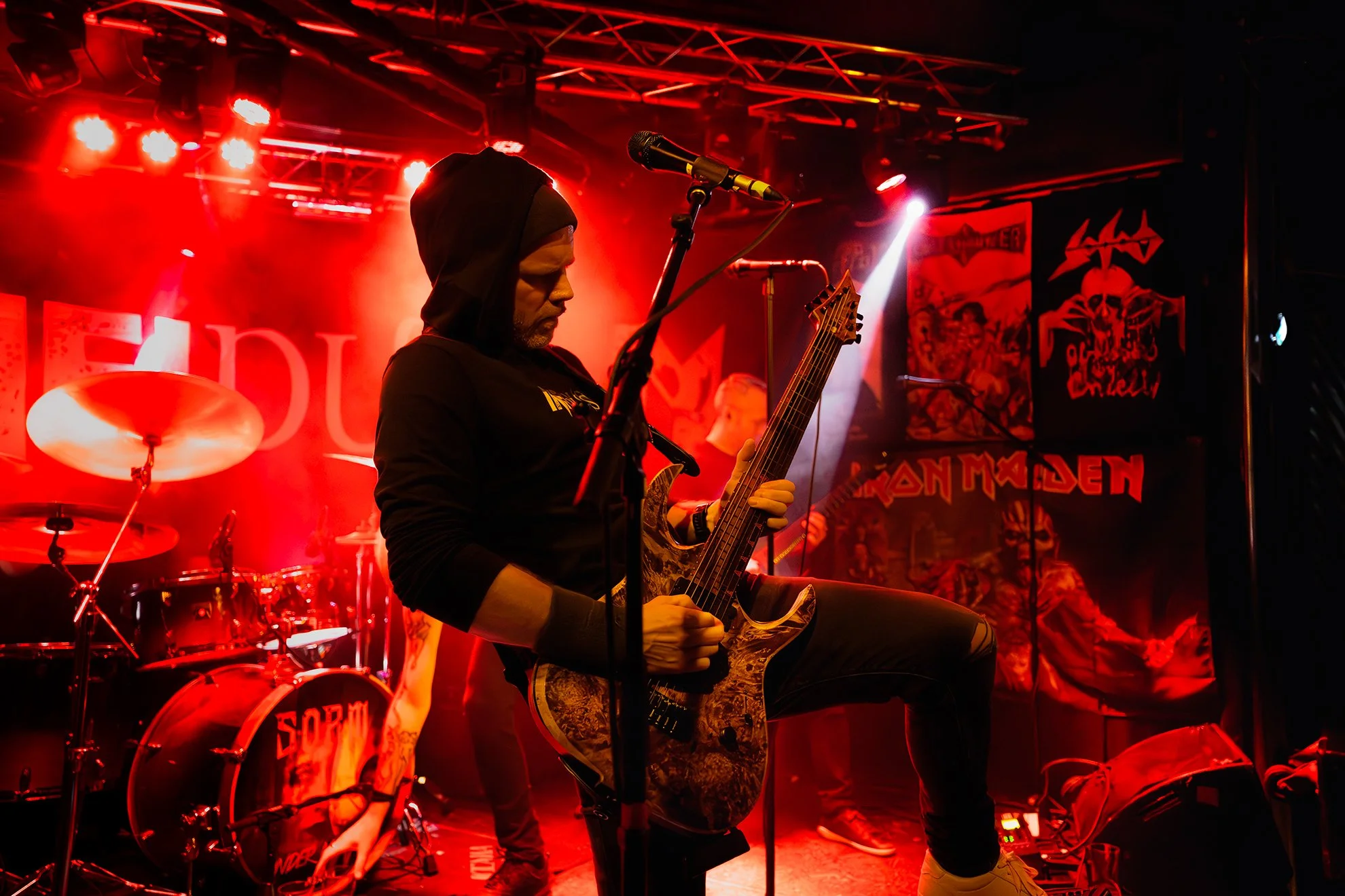 En musiker som spiller på en elektrisk gitar under en konsert med røde lys.