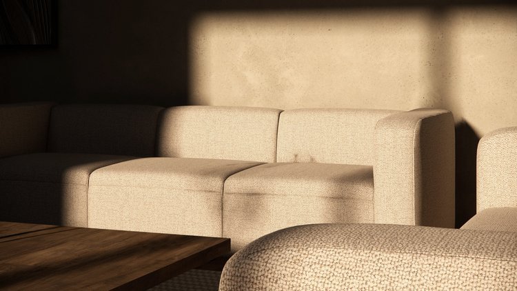 Sunlit beige fabric sofa in a living room with wooden coffee table.