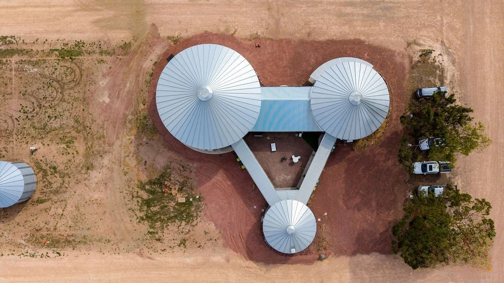 Aerial view of the Paskeville Field Days facility, three round silo-style buildings linked around a central courtyard