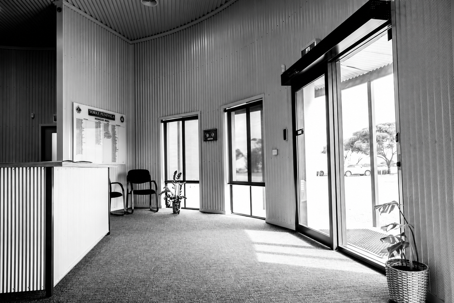 Reception area inside the Paskeville Field Days facility, with corrugated steel walls and glass doors to the entry