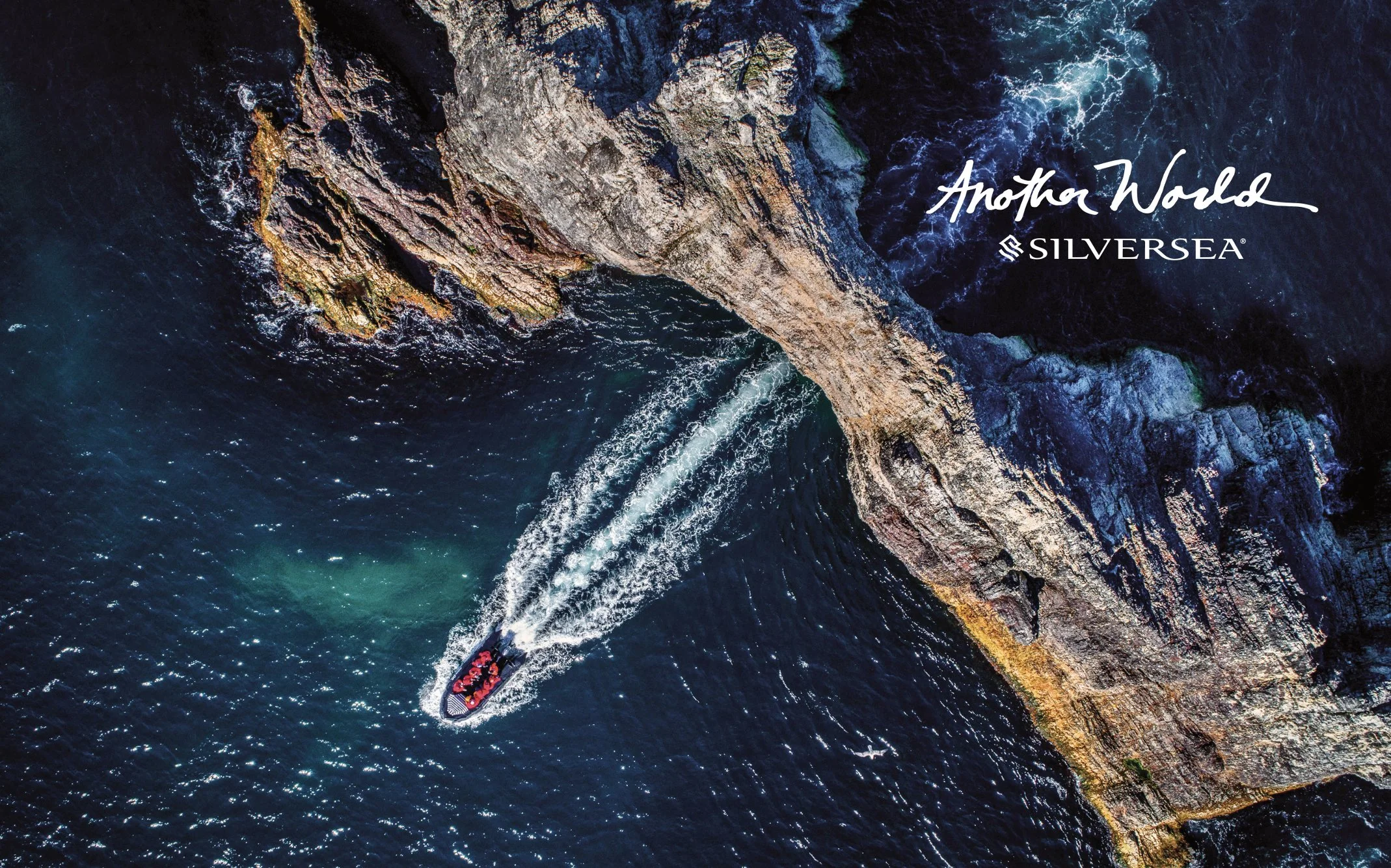 Silversea Another World: a boat cutting through a dark sea, seen from above