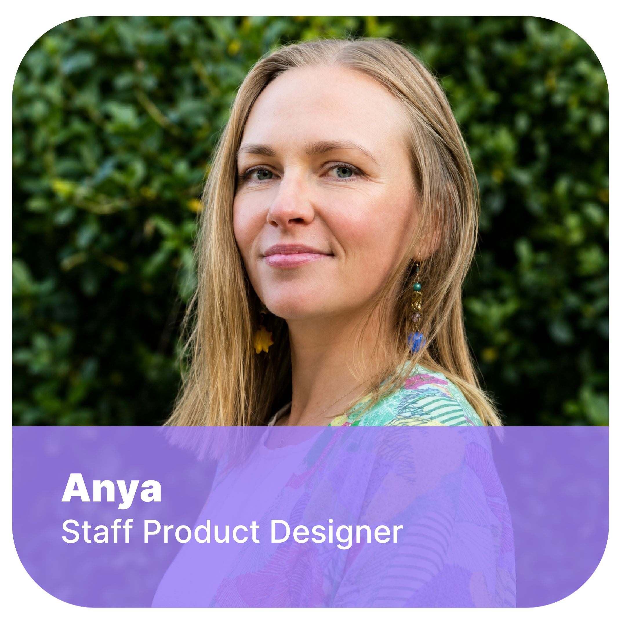 Close-up of a woman with light skin, blonde hair, and blue eyes, outdoors with greenery in the background. She is wearing earrings and a colorful, patterned top. The lower part of the image contains a purple banner with white text that reads "Anya Staff Product Designer."