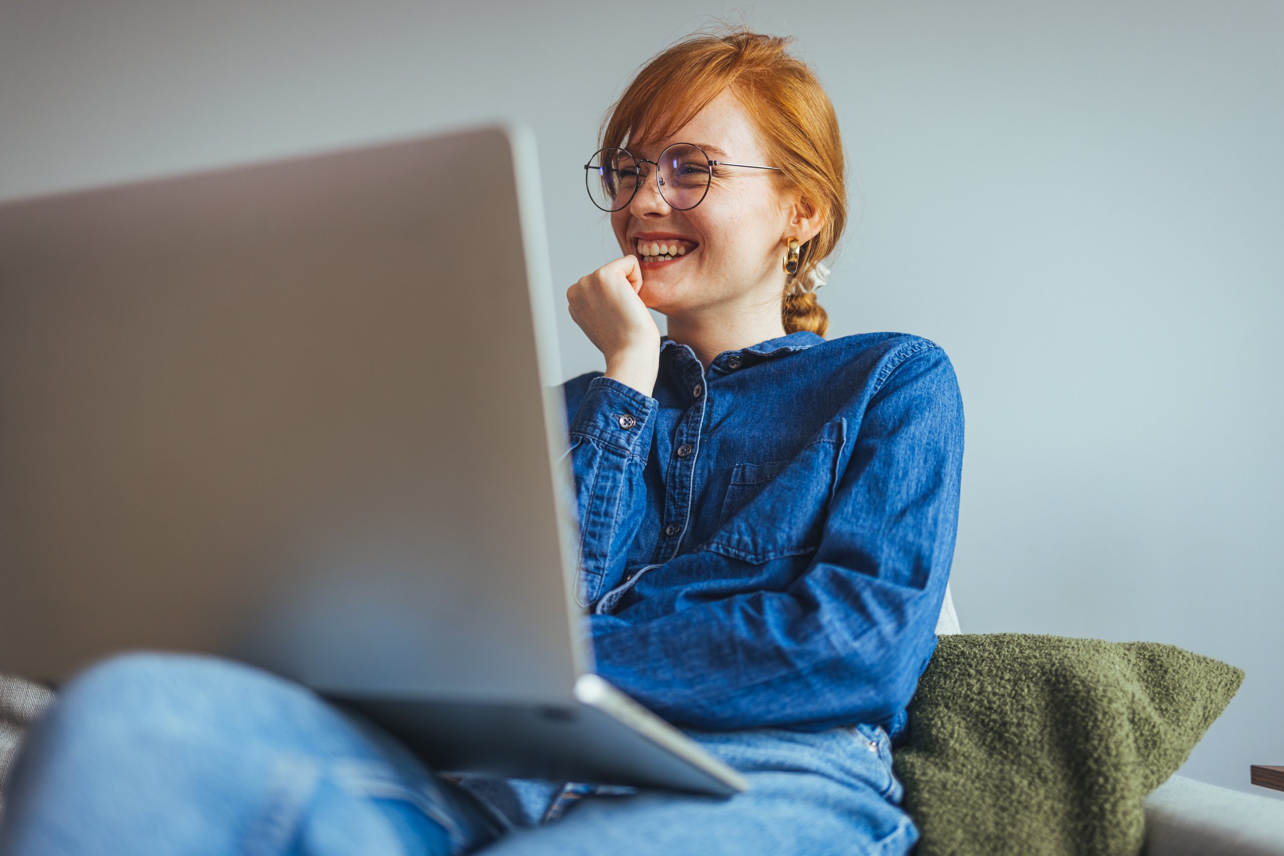 Happy small business owner researching commercial insurance in Ontario on a laptop