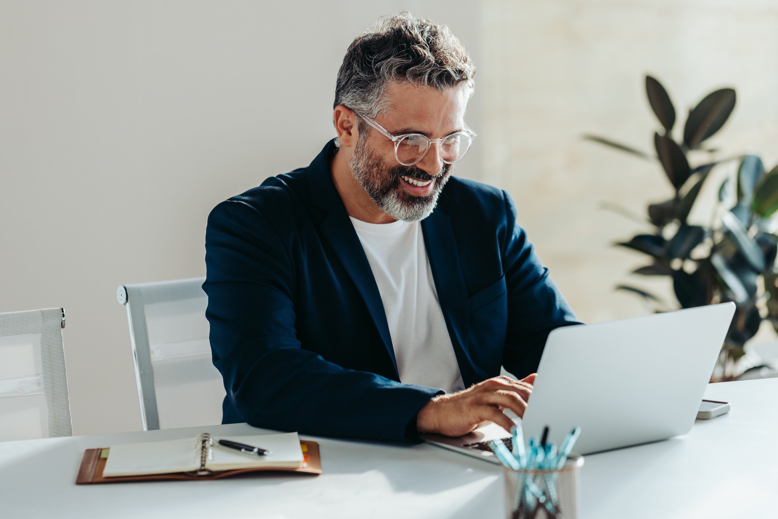 Mature business professional managing policies on laptop — stress-free experience with commercial insurance solutions.