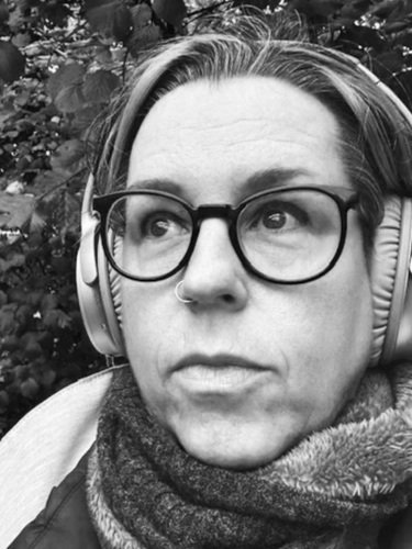 Tree Blackmore wearing noise-cancelling headphones because of tinnitus and hyperacusis.