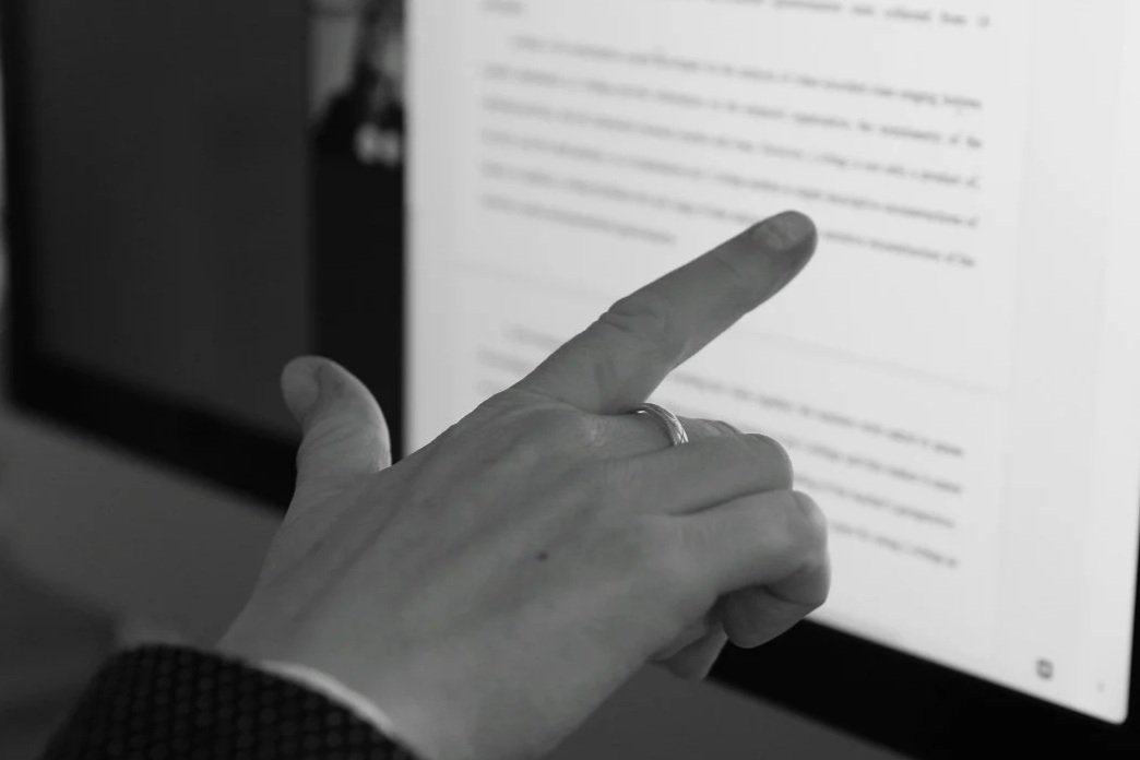 private online English teacher Tree Blackmore's hand pointing to text on a computer screen.