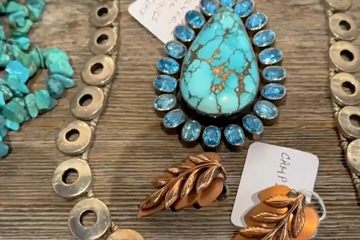 Turquoise jewelry display featuring a large turquoise pendant, silver bracelets, and vintage earrings at Camp Bubba Antiques in Johnson City, Texas.
