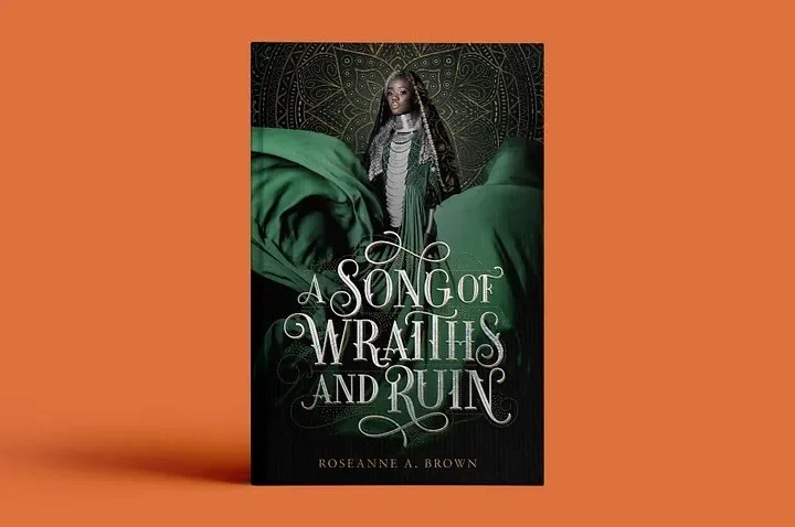  A book on an orange background. The book is called "A Song of Wraiths and Ruin" which is written in swirly type. Behind the title is a Black woman with silver hair wearing a flowy green and silver dress and a black and silver scarf on her head. She 
