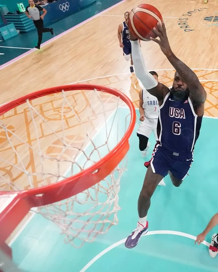  The basketball court from the Olympics with a basketball pattern on the floor and a blue rectangle 