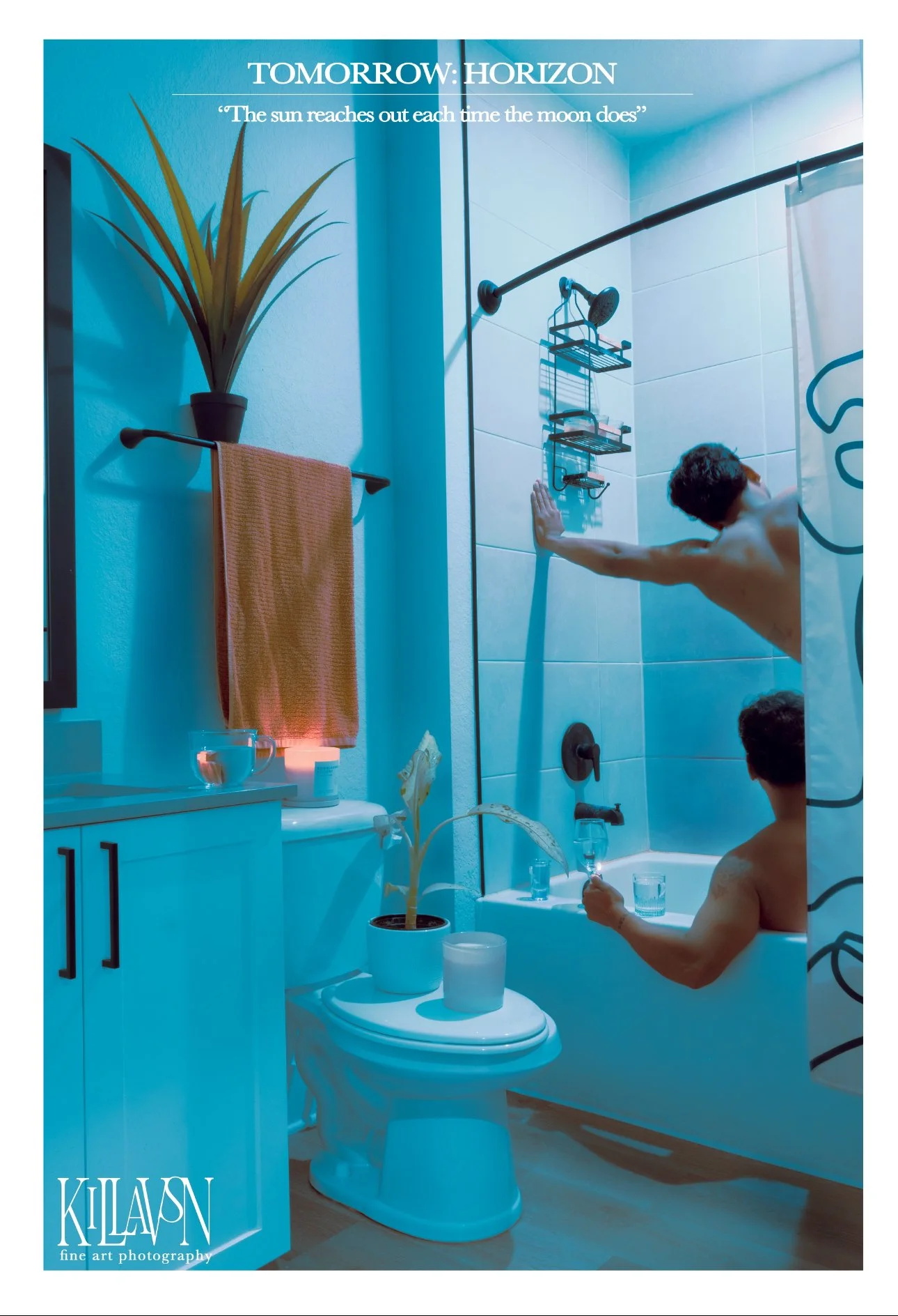 Two shirtless men in a bathroom, one in the shower and one in the bathtub, holding glasses. The bathroom has a potted plant, a towel, a lit candle, and bottles on the bathtub edge. The shower has a curtain, and there is a bathroom cabinet with a glas