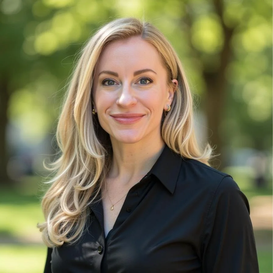 Aimee St Peter Headshot. Woman in a nature setting wearing a black shirt.