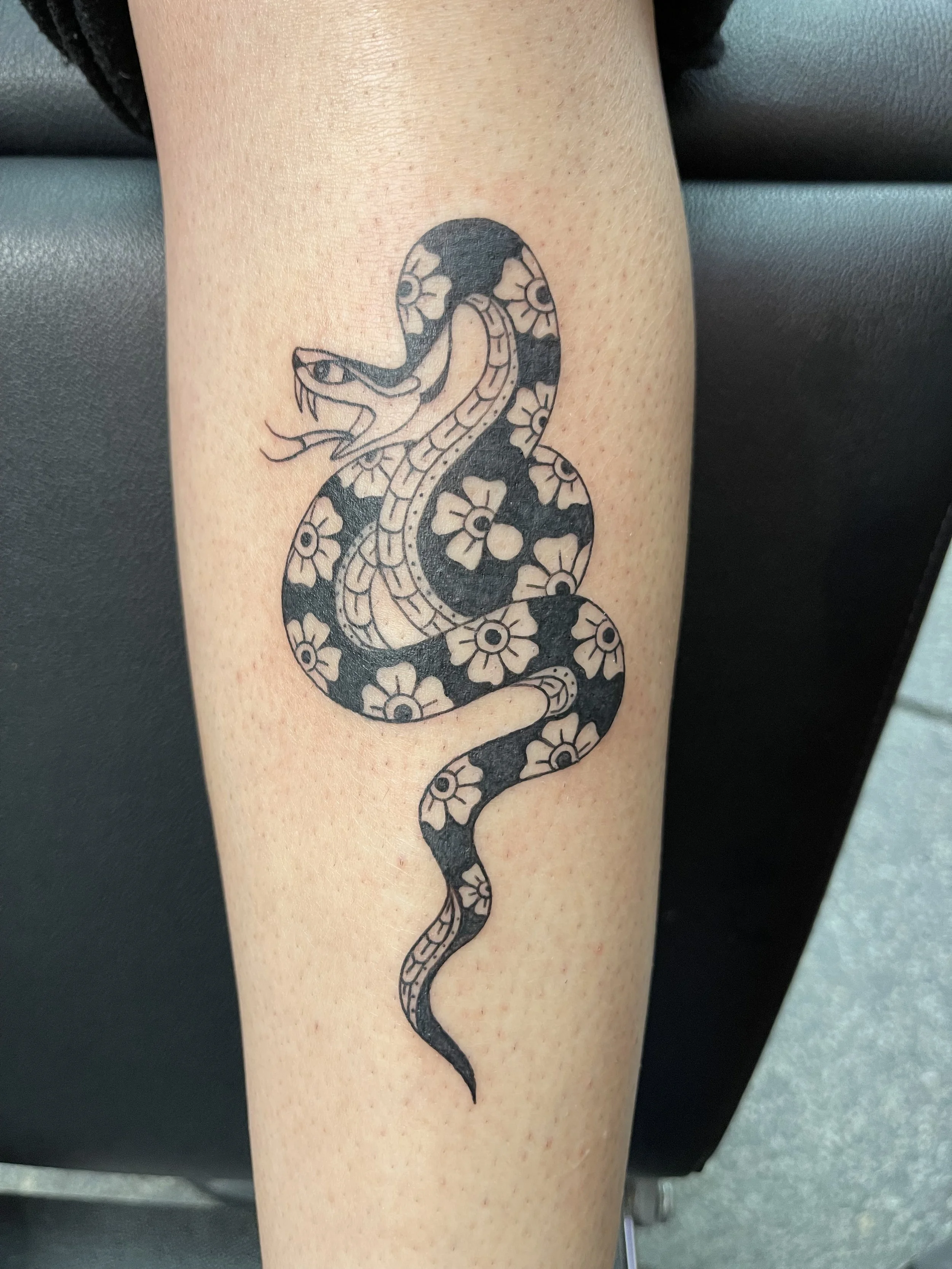 flowered snake traditional black tattoo.jpeg