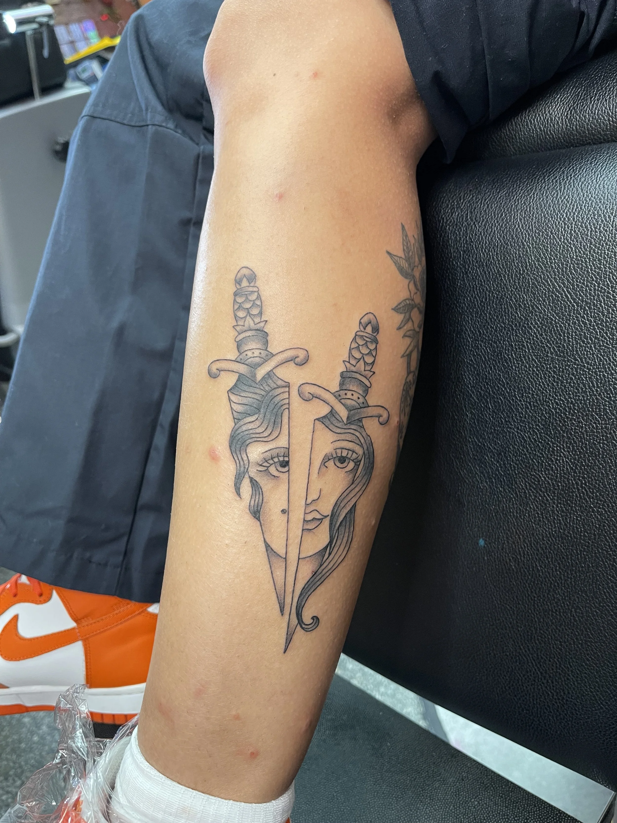 two daggers faces tattoo.jpeg