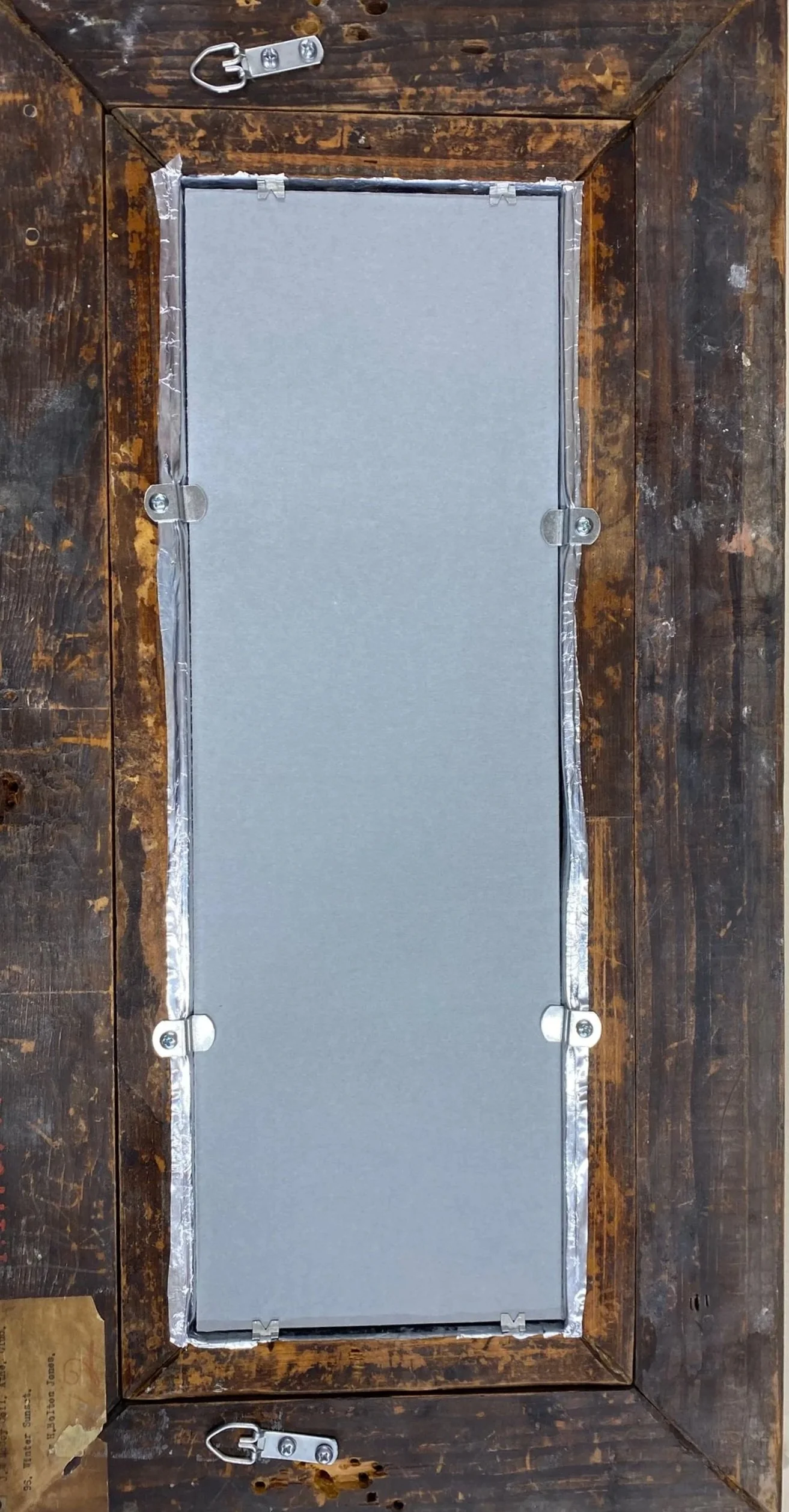 After framing. Lignin-free backing board behind the artwork is held in by improved framing hardware.